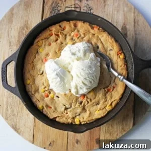 Peanut Butter Skillet Cookie. Homemade peanut butter cookie dough with Reeses Pieces baked until ooey gooey and topped with vanilla ice cream and hot fudge.