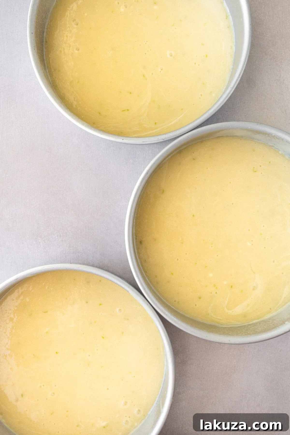 Zesty Key Lime Indulgence 9 Pour key lime cake batter into three 8-inch cake pans before baking.