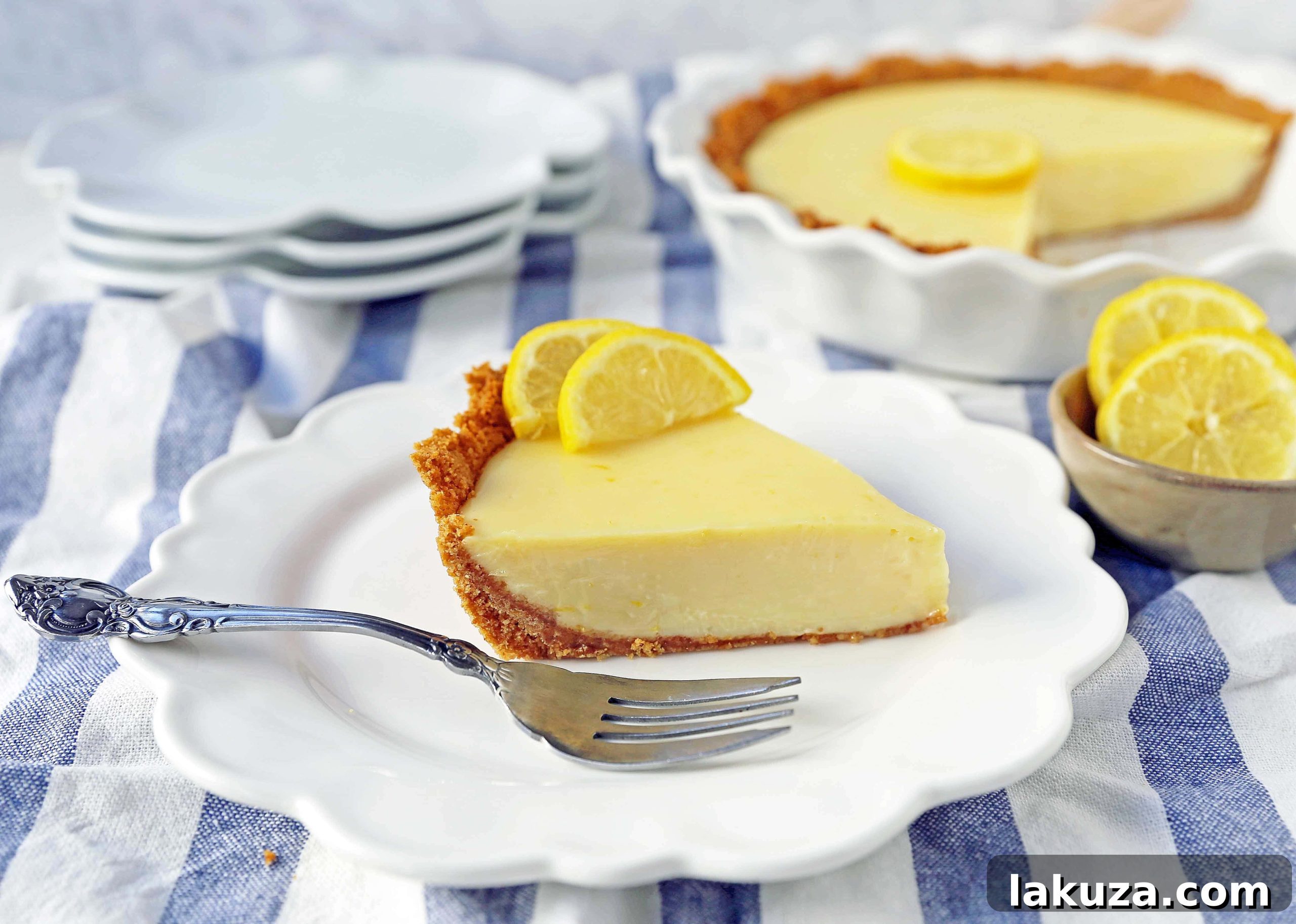 An overhead shot of a full Lemon Cream Pie, with its smooth, pale yellow filling and a delicate border of whipped cream. The pie sits on a rustic wooden surface, inviting indulgence.