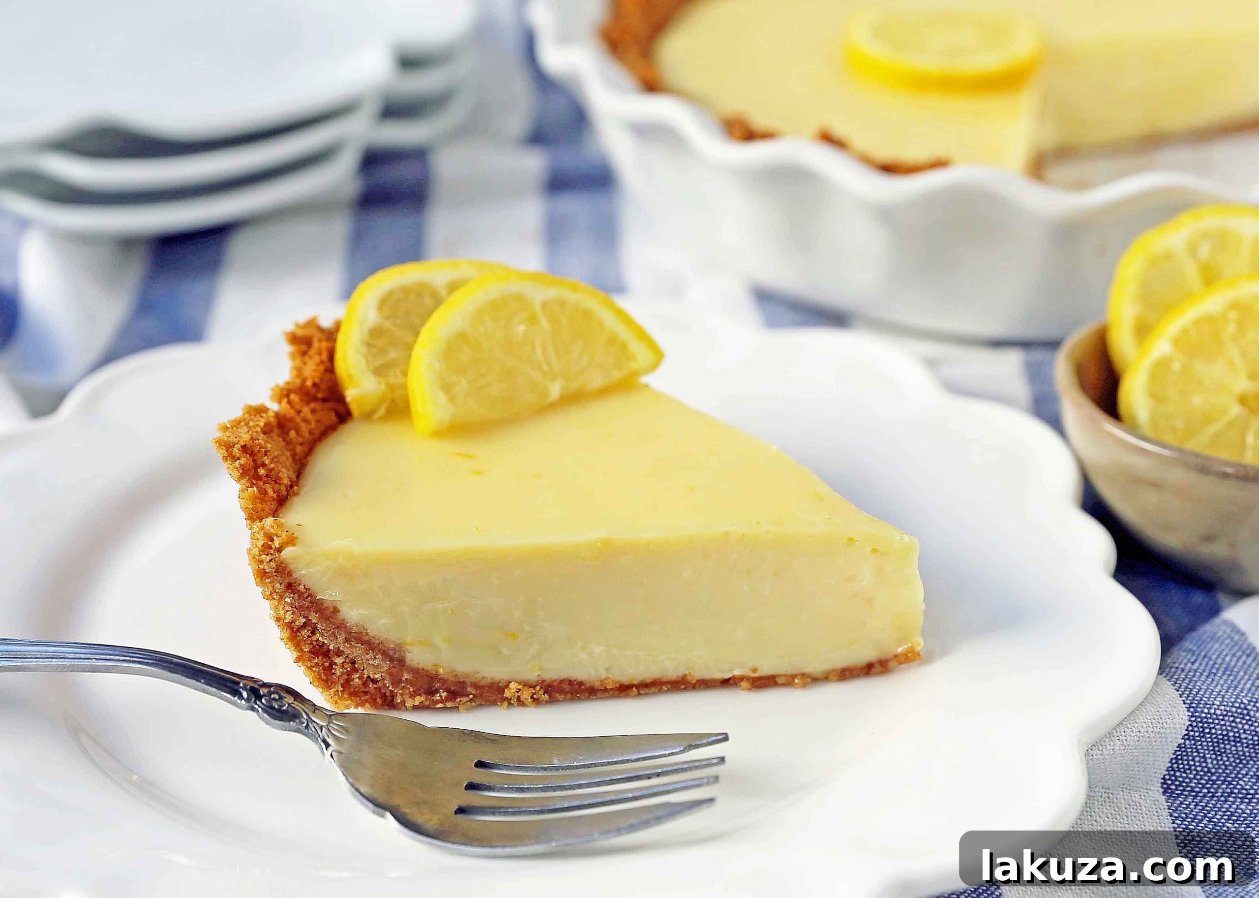 A stunning high-angle shot of the Lemon Cream Pie, featuring a perfect slice removed, revealing the velvety interior and the sturdy crust.