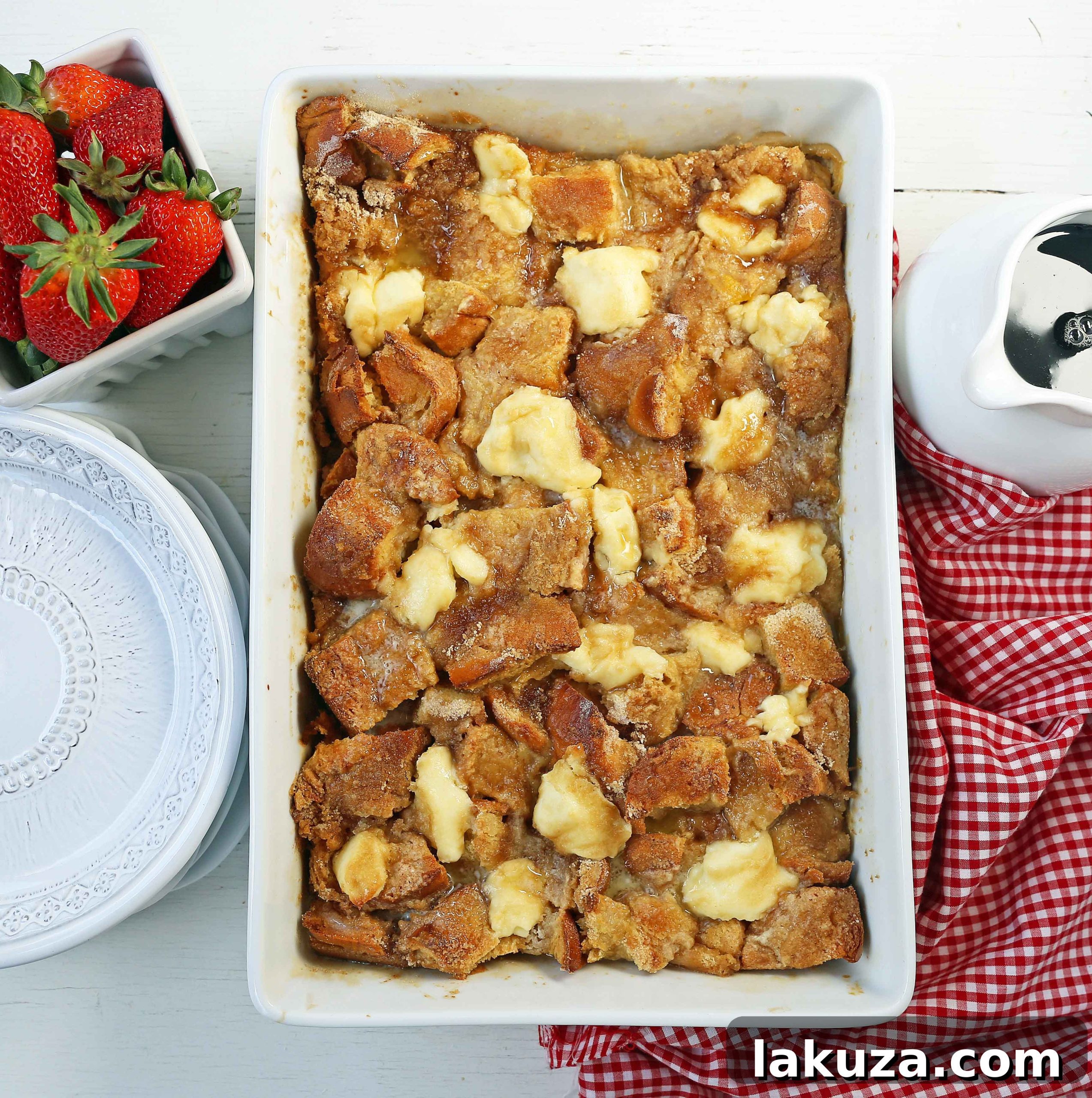 Brunch Bliss French Toast 4 Overnight French Toast Casserole in a baking dish, showcasing cubed bread, creamy dollops, and a crumbly streusel topping, ready for baking.