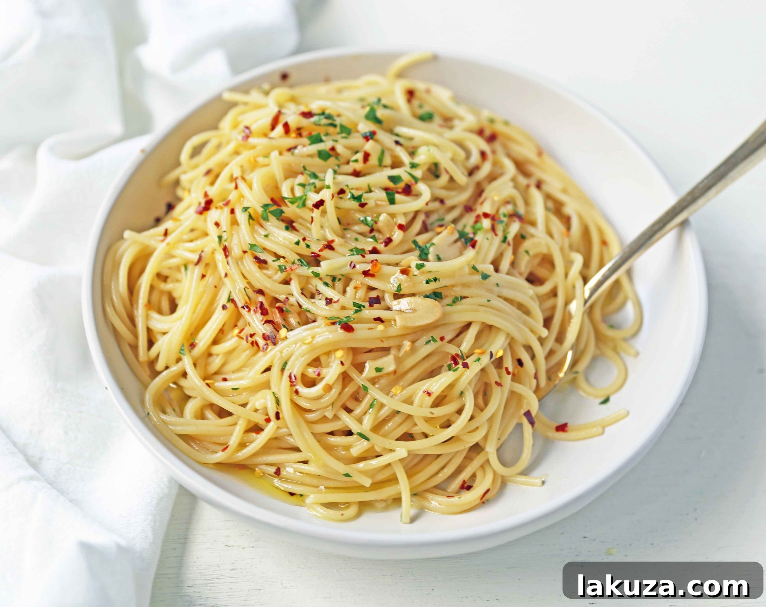 Ingredients for Spaghetti Aglio e Olio laid out, including fresh garlic, olive oil, red pepper flakes, and spaghetti.