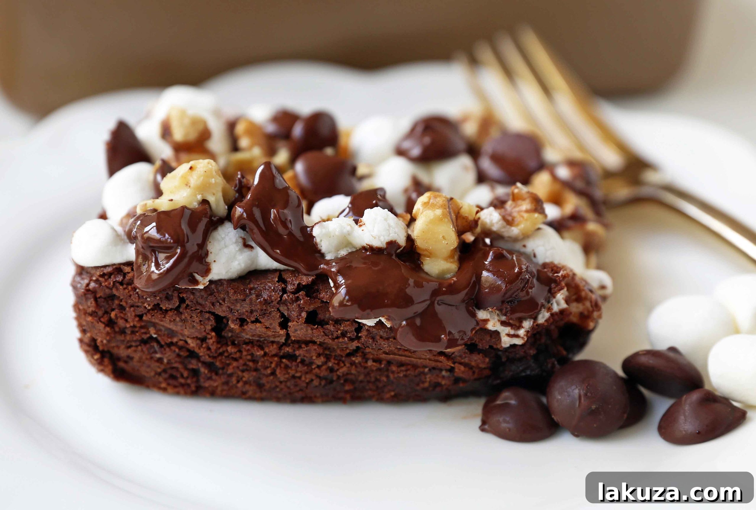 A slice of Rocky Road Brownie with visible layers of rich chocolate, soft marshmallows, and crunchy walnuts.