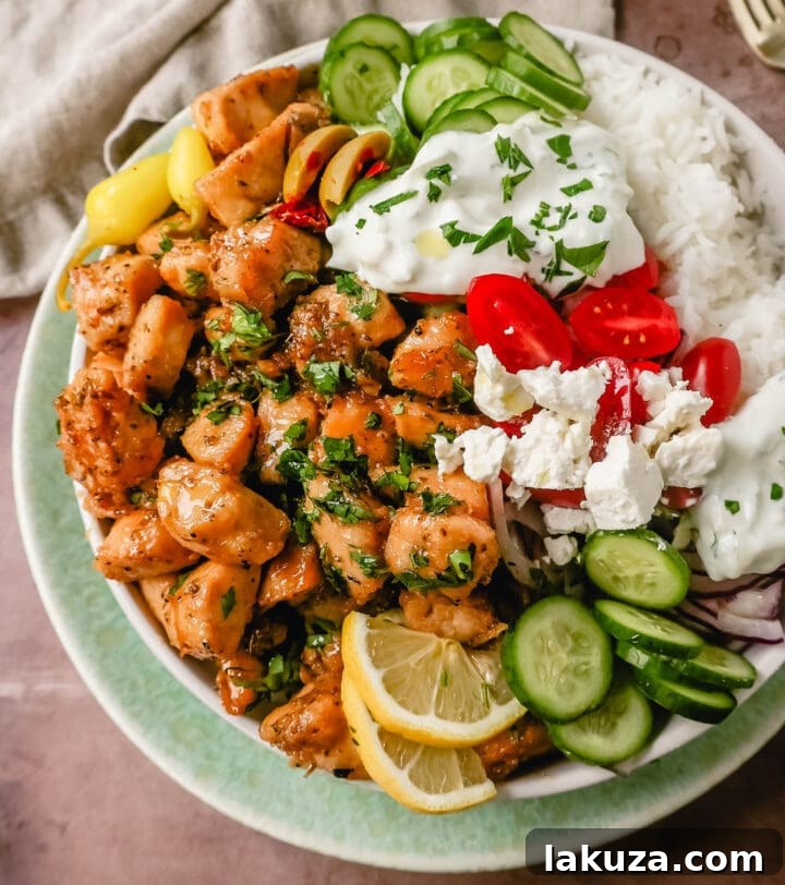 Grecian Harvest Bowls 3 Preparation of Greek Chicken Bowls: Marinated grilled chicken, fresh chopped vegetables, and creamy tzatziki ready for assembly.