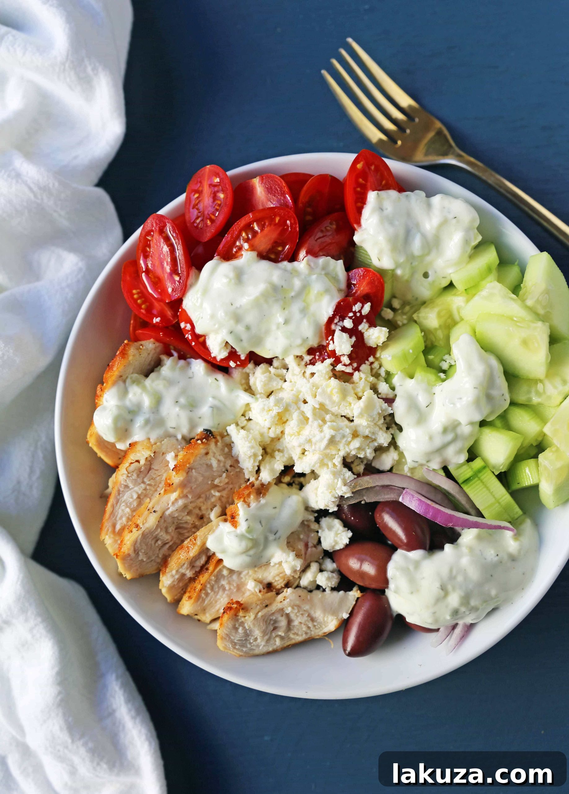 Grecian Harvest Bowls 4 Assembled Greek Chicken Bowls showcasing grilled chicken, colorful vegetables, feta, olives, and a generous dollop of tzatziki sauce. Ideal for healthy eating and meal prep.