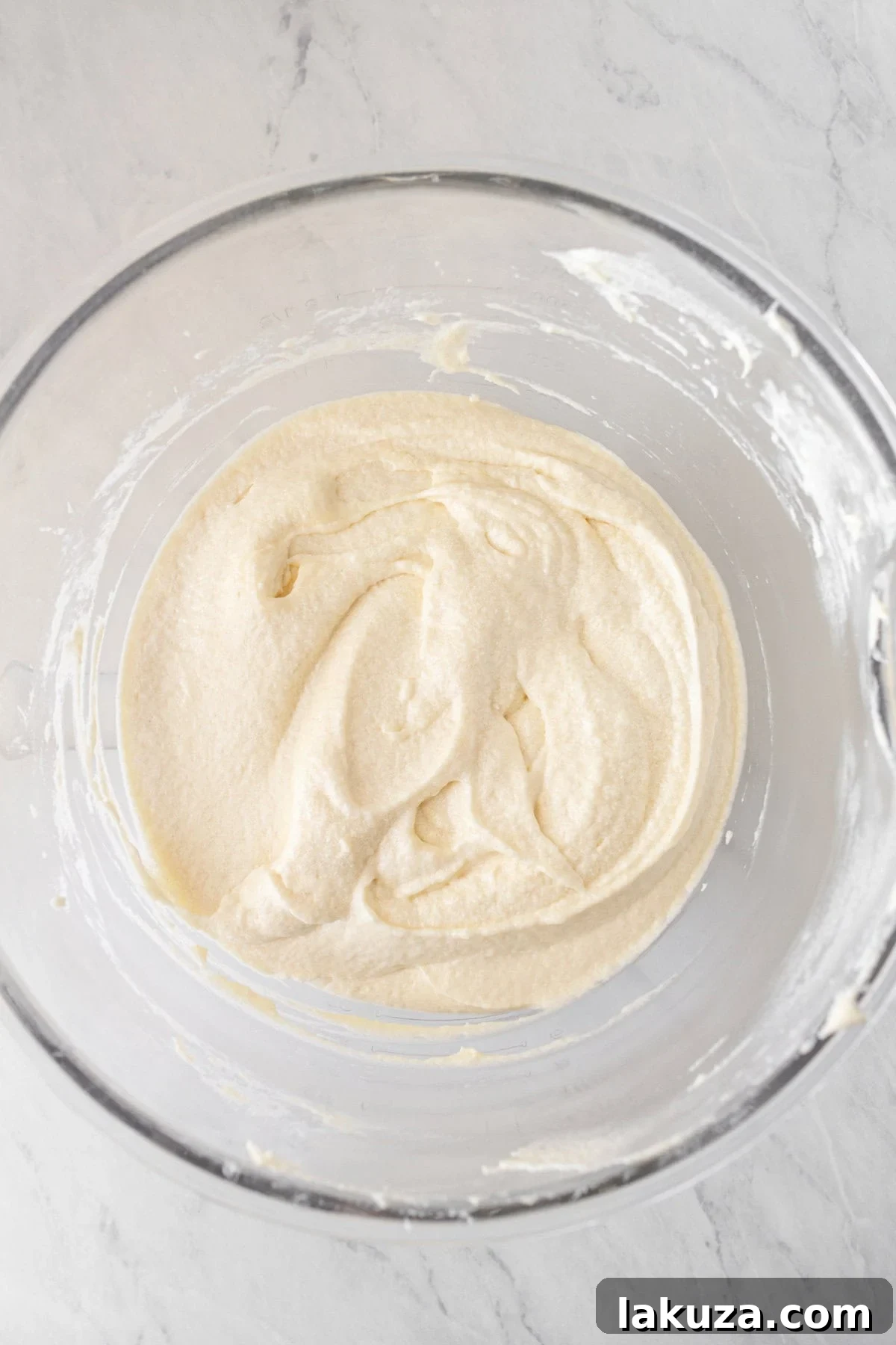 Homemade vanilla buttercream frosting in a mixing bowl, smooth and creamy.