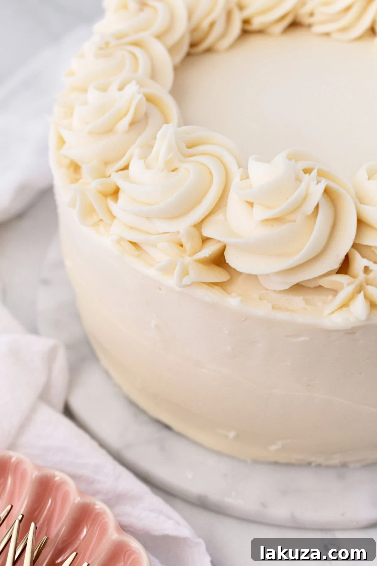Overhead shot of a full vanilla cake with vanilla bean buttercream frosting, ready to be served.
