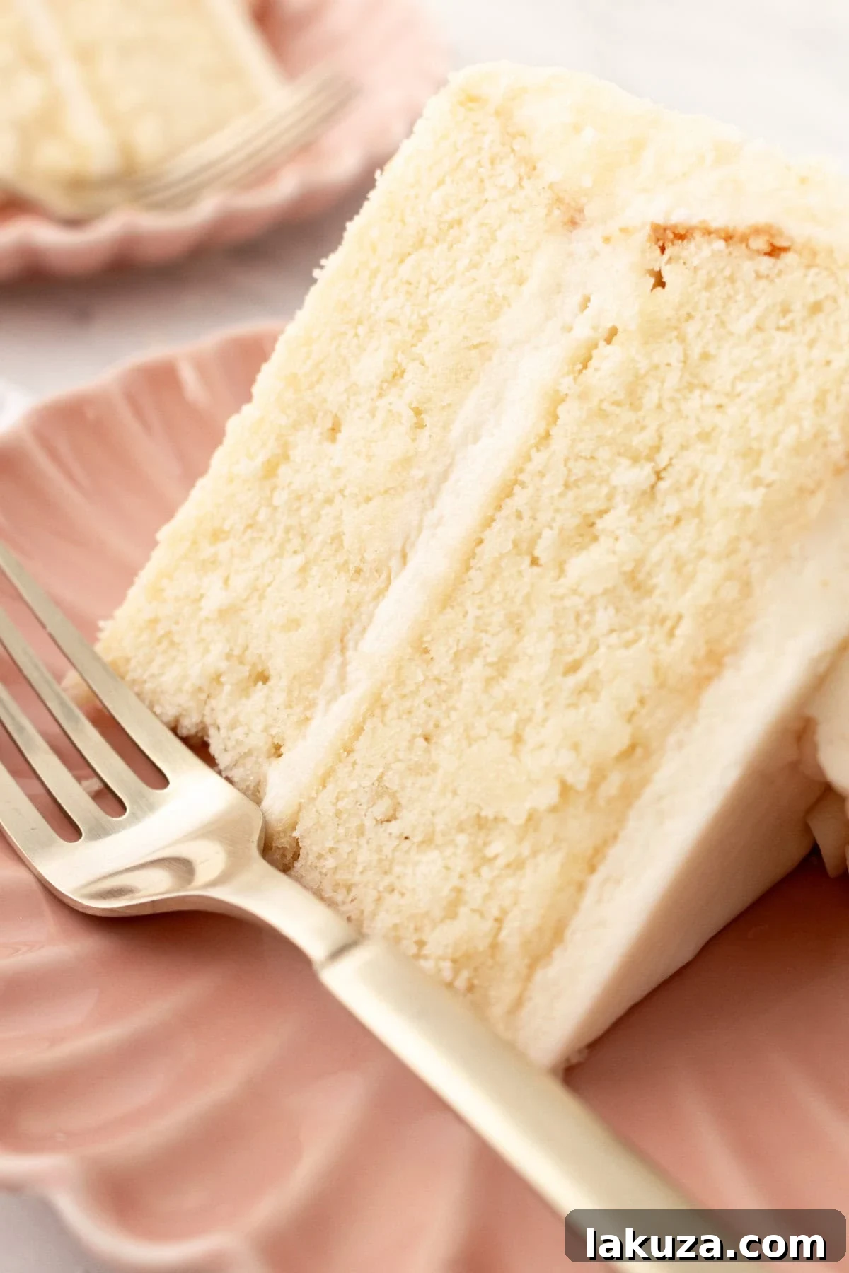Side view of a perfectly frosted vanilla cake, highlighting its layers and smooth buttercream.