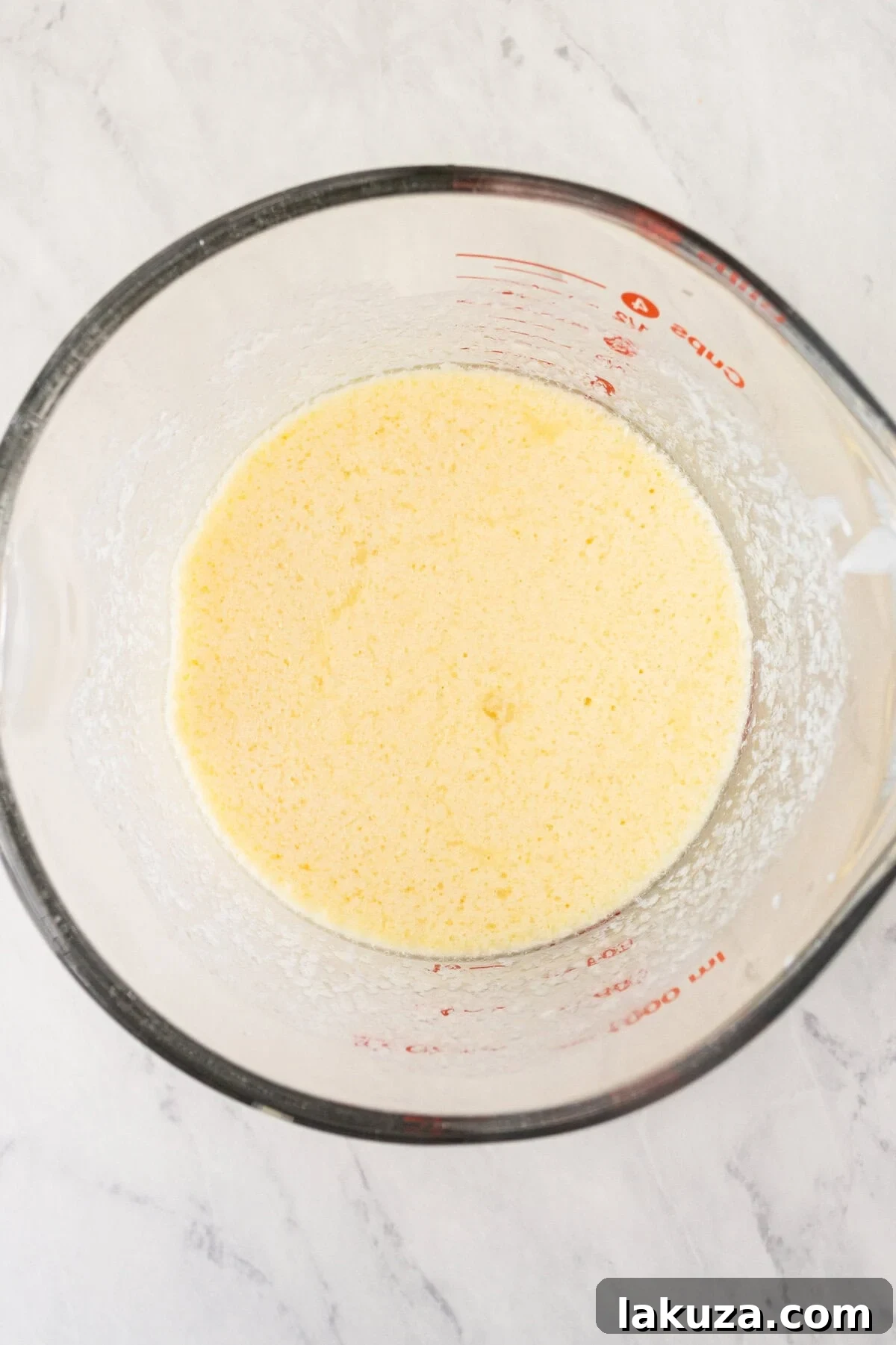 Vanilla cake batter in a mixing bowl, showcasing its smooth consistency.