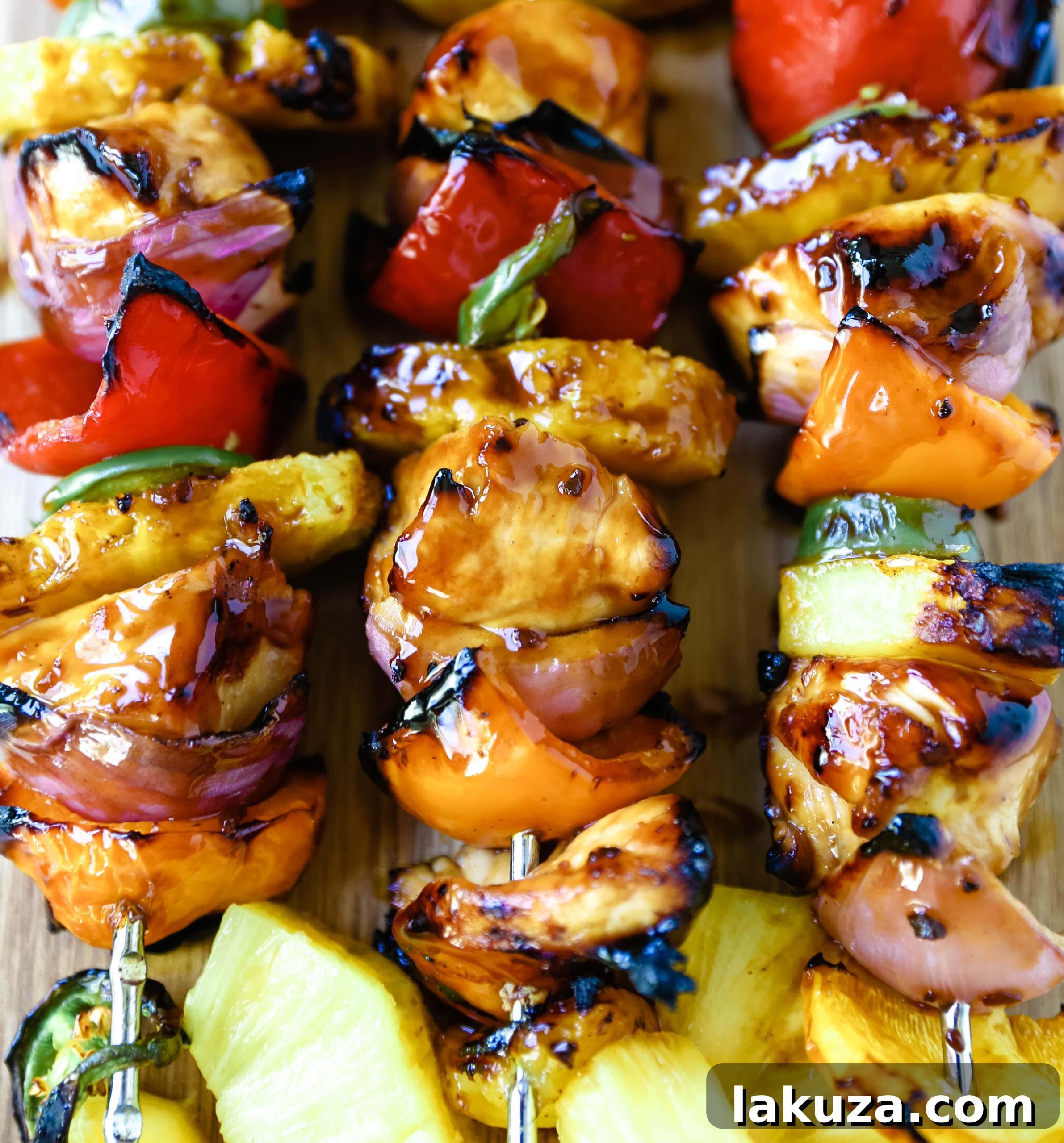 Aloha Teriyaki Chicken Skewers 3 Close-up of freshly grilled Hawaiian Teriyaki Chicken Skewers with charred vegetables and caramelized pineapple, glistening with sauce.