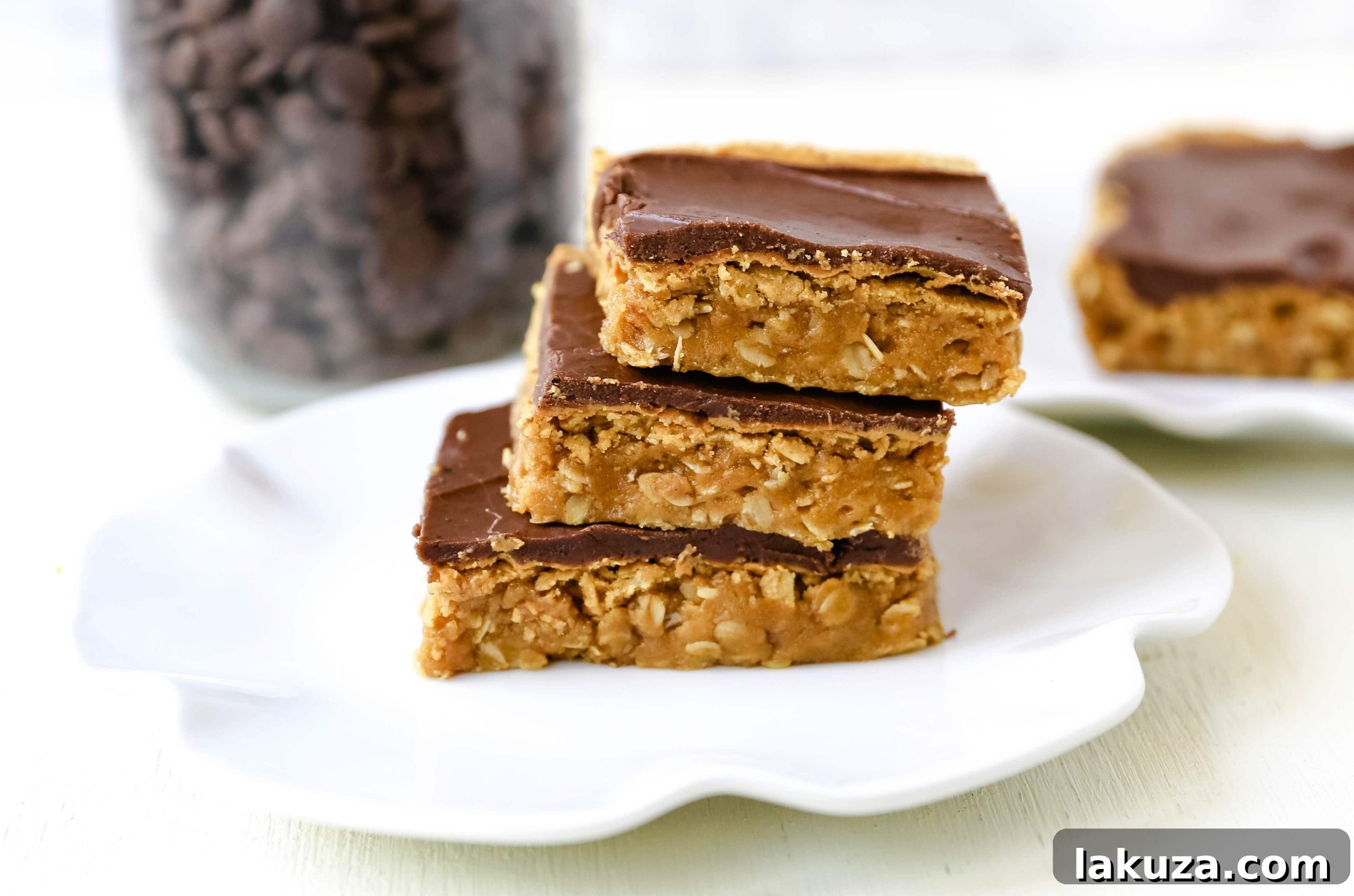 Close-up shot of rich Chocolate Peanut Butter Cookie Bars, showcasing the layers of peanut butter oatmeal cookie and thick chocolate frosting, ready to be enjoyed.