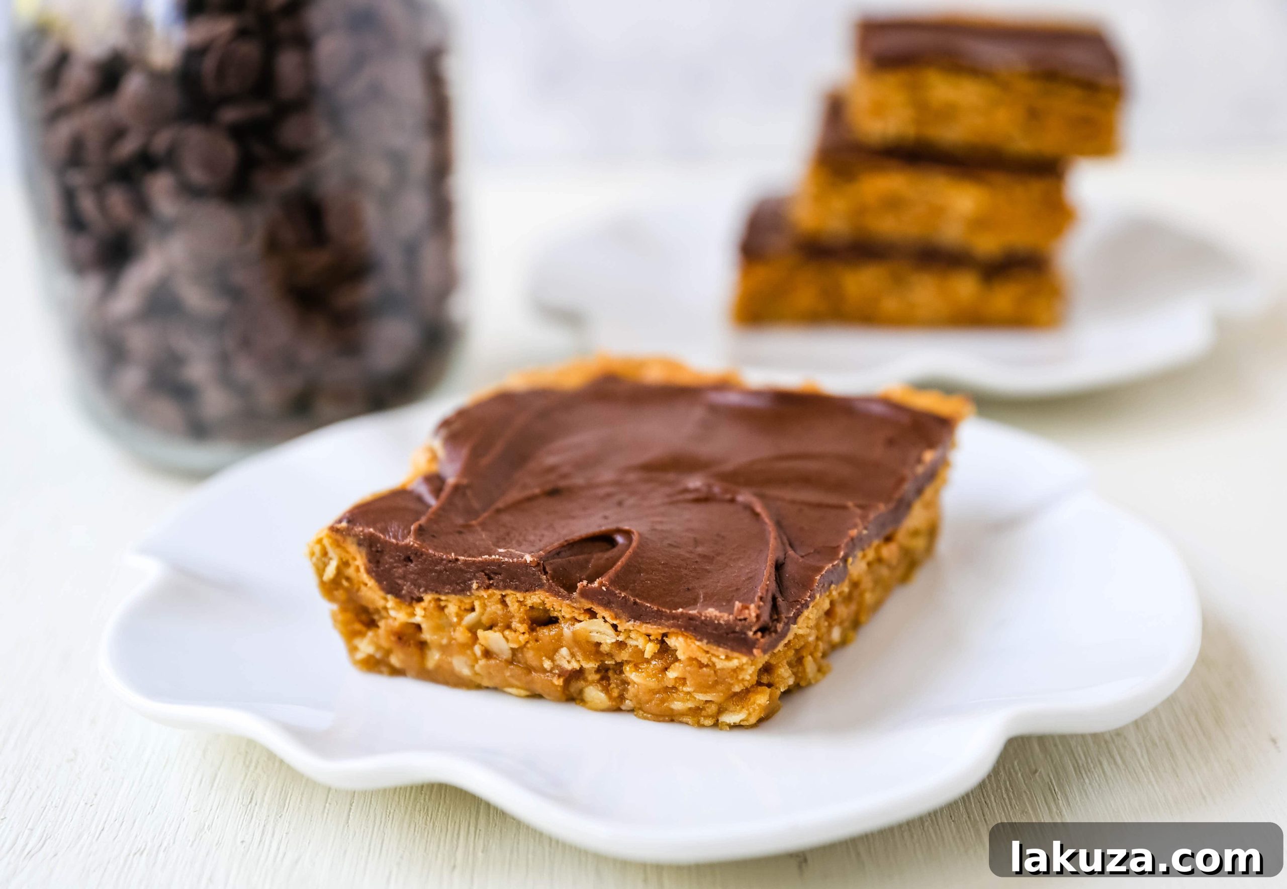 A large pan of freshly baked Chocolate Peanut Butter Cookie Bars, with a few pieces already cut, ready to be served at a gathering.
