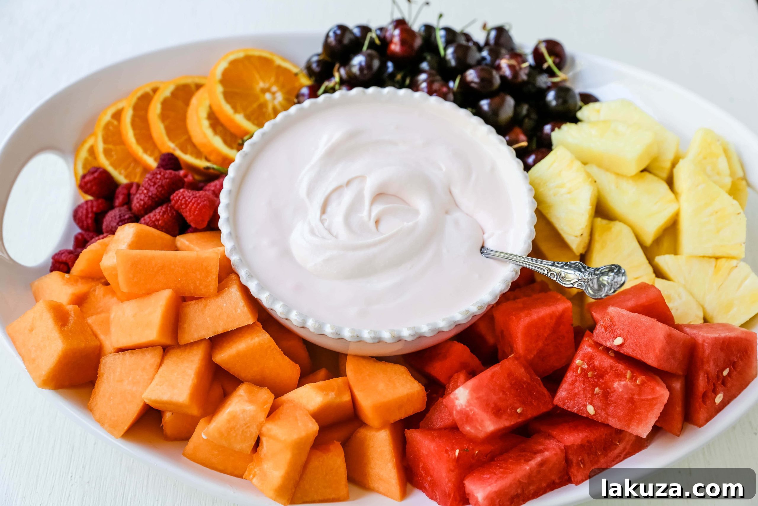 Creamy Fruit Delight 6 A vibrant platter of assorted fresh fruits like strawberries, pineapple, grapes, and melon, perfect for dipping.