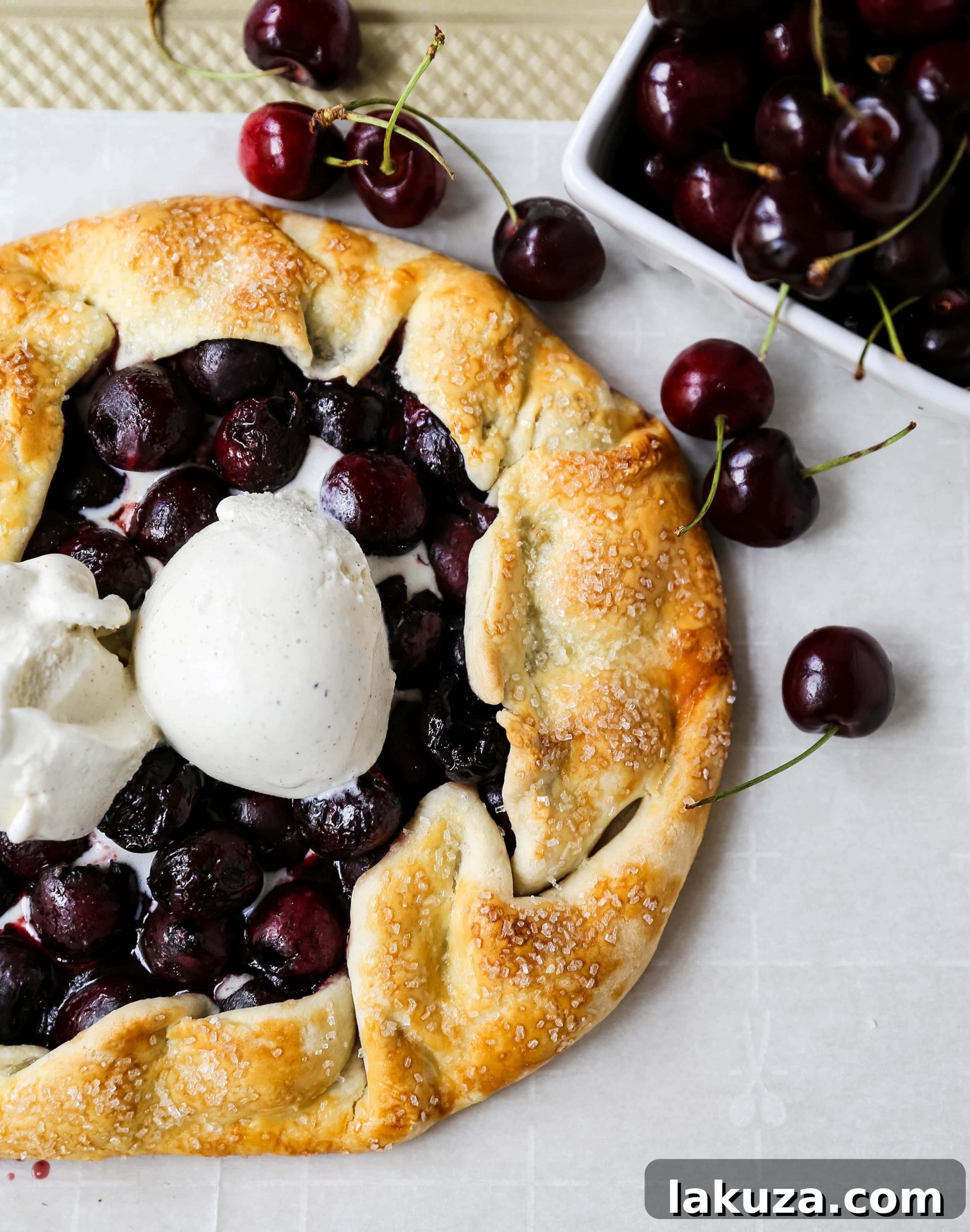 Unbaked cherry galette, with fresh pitted cherries arranged on a homemade pie crust before folding the edges.