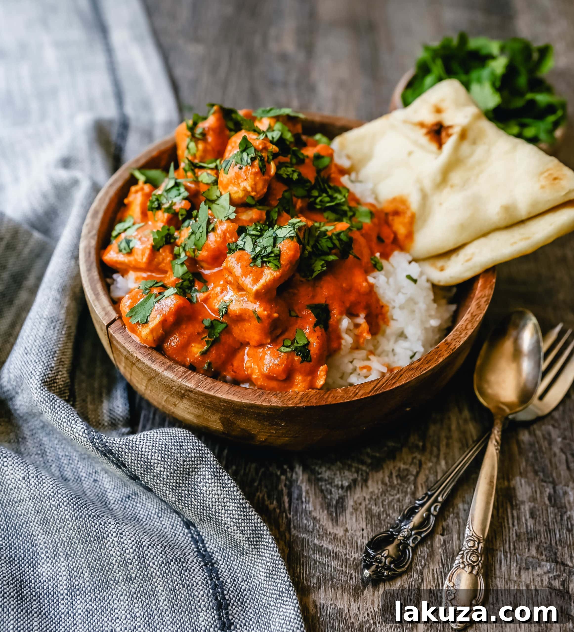 Velvety Indian Butter Chicken 5 Platter of Indian Butter Chicken with a side of freshly baked Naan bread, ready for a family meal.