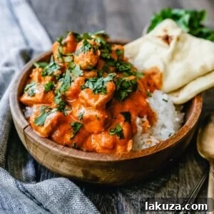 Indian Butter Chicken served with naan bread, highlighting the tender chicken pieces and the vibrant sauce.
