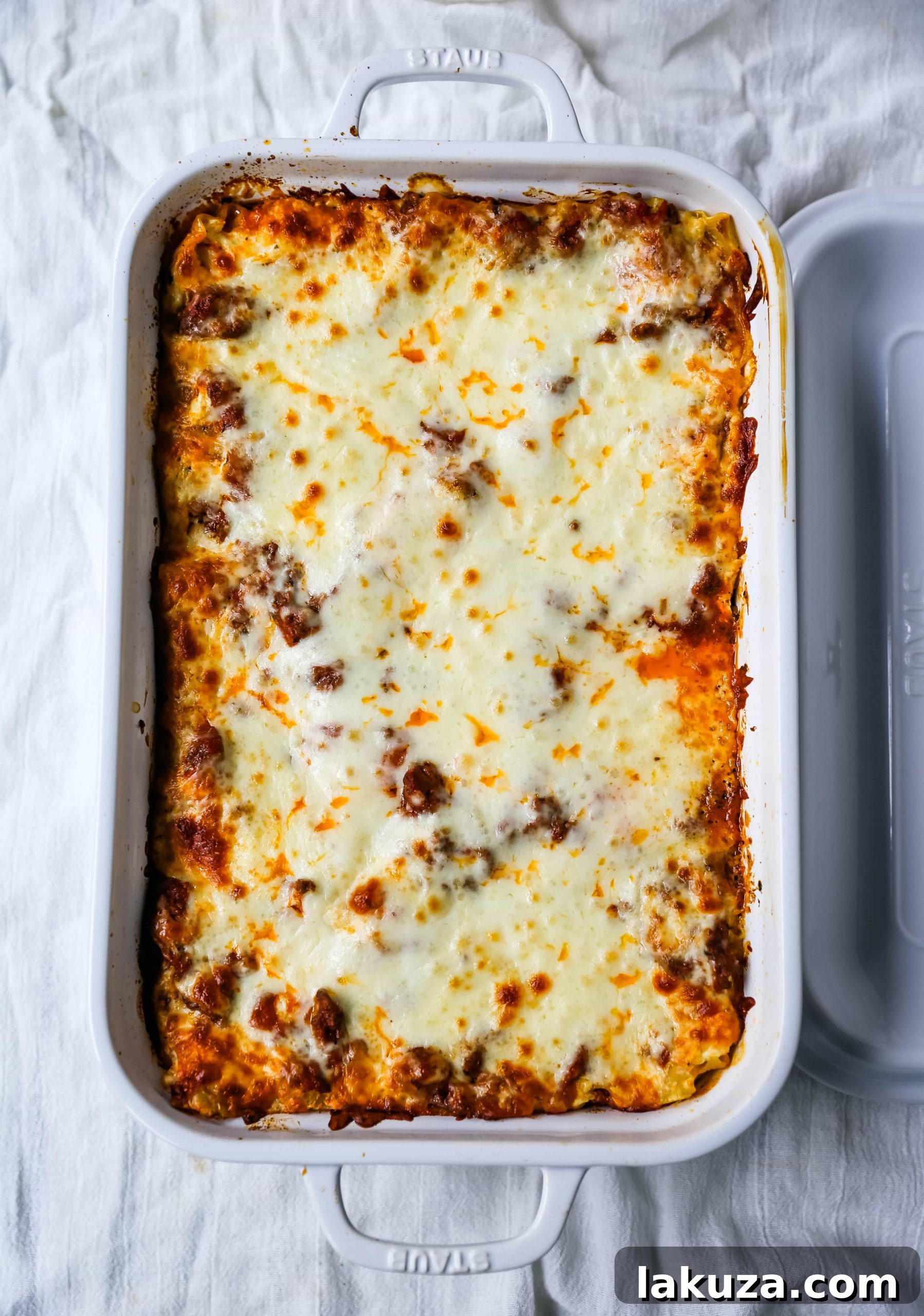 A side view of a generous slice of Classic Lasagna, showcasing its distinct layers of pasta, rich meat sauce, and creamy cheese filling.