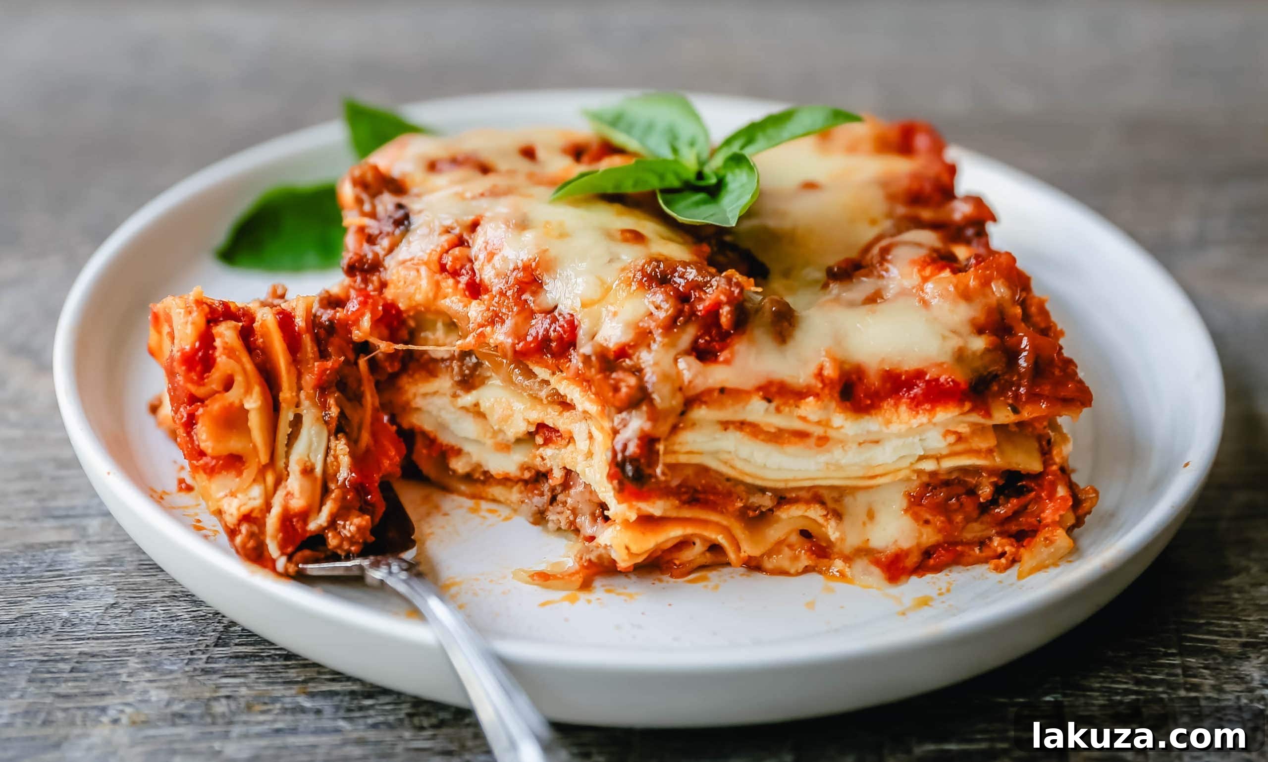 A close-up of a serving of Classic Lasagna, showing the steam, melted cheese, and tender layers, garnished with fresh basil.