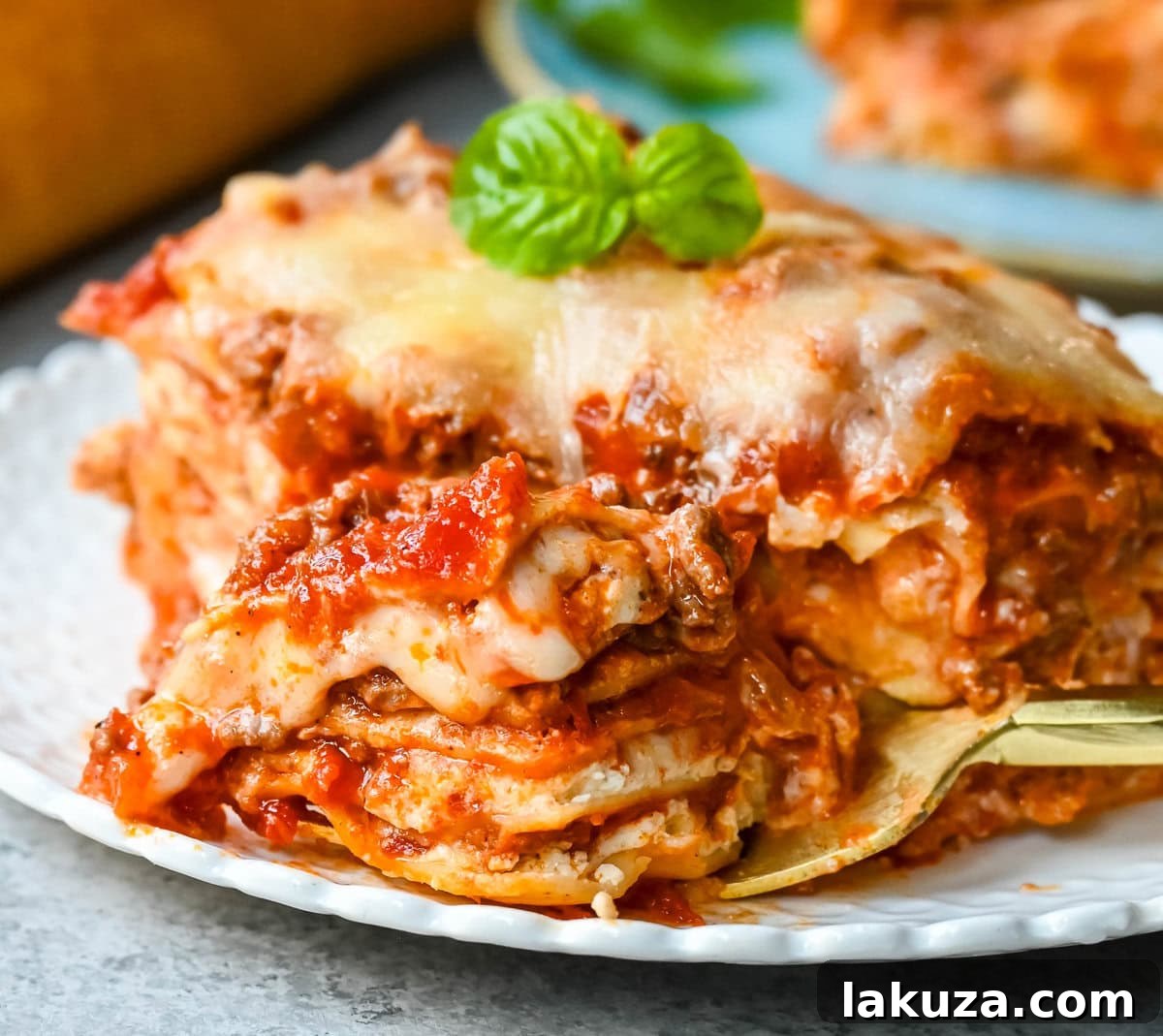 The process of layering lasagna with noodles, ricotta cheese, meat sauce, and mozzarella cheese.