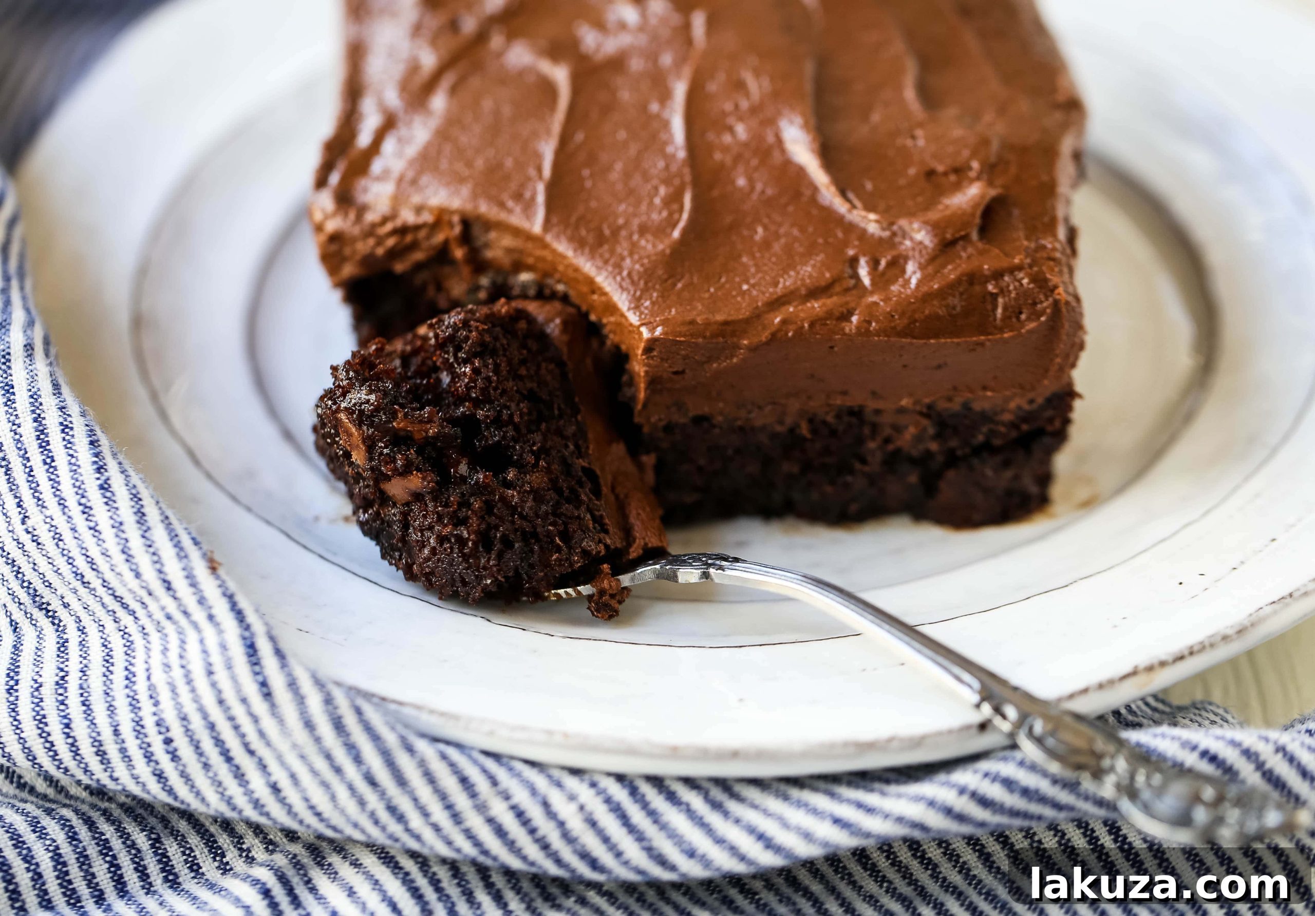 Moist chocolate zucchini cake with rich chocolate buttercream frosting, a perfect way to eat your vegetables without realizing it. The Best Chocolate Zucchini Cake Recipe.