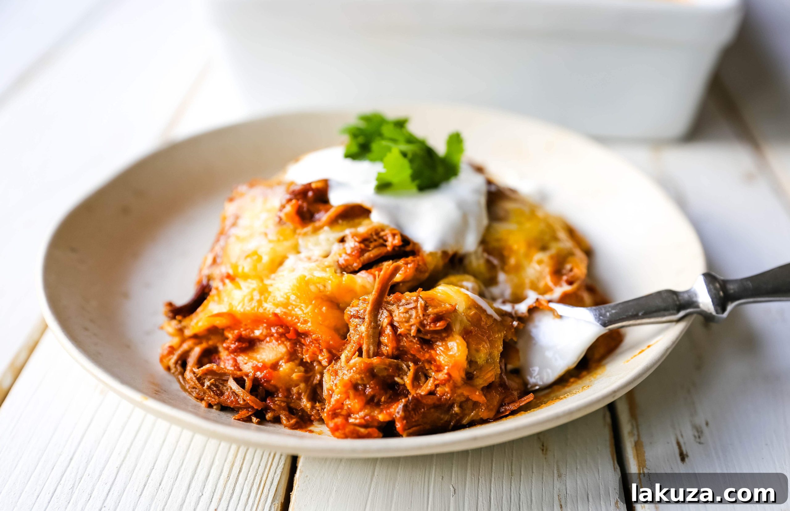 Stacked Beef Enchiladas layering process: Mexican seasoned shredded beef, melted cheese, corn tortillas, and homemade enchilada sauce creating an easy beef enchilada casserole.