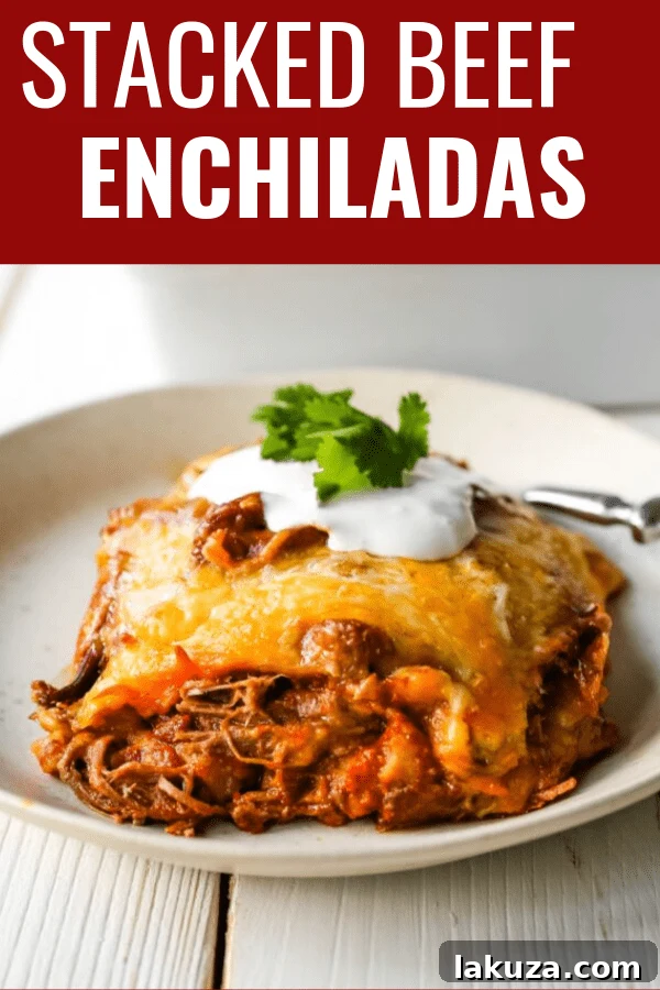 A close-up shot of hot Stacked Beef Enchiladas, garnished with fresh cilantro and a dollop of sour cream, showcasing the melted cheese and tender shredded beef.