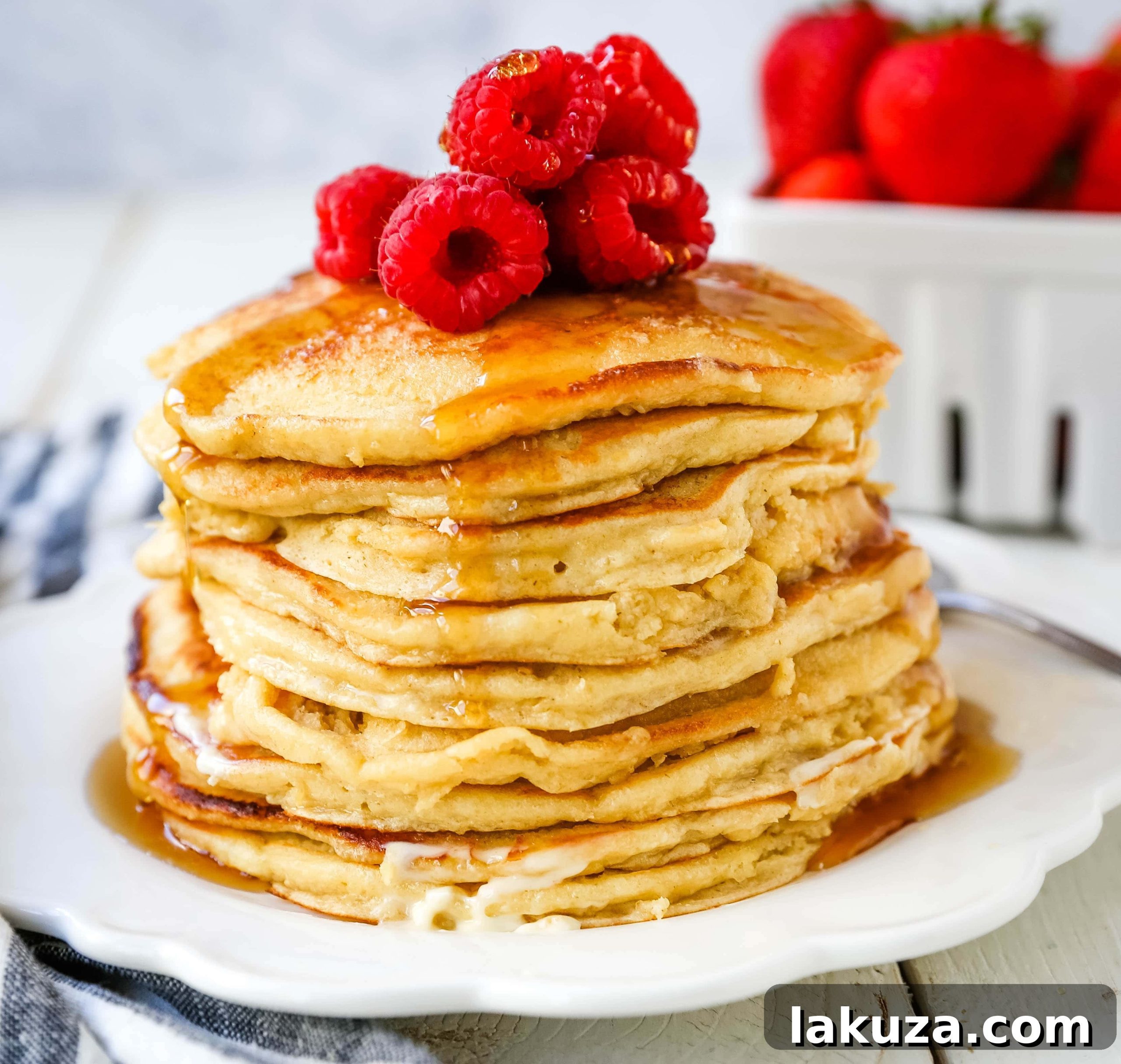 A stack of golden cottage cheese pancakes garnished with fresh blueberries and a light dusting of powdered sugar, served on a rustic plate.