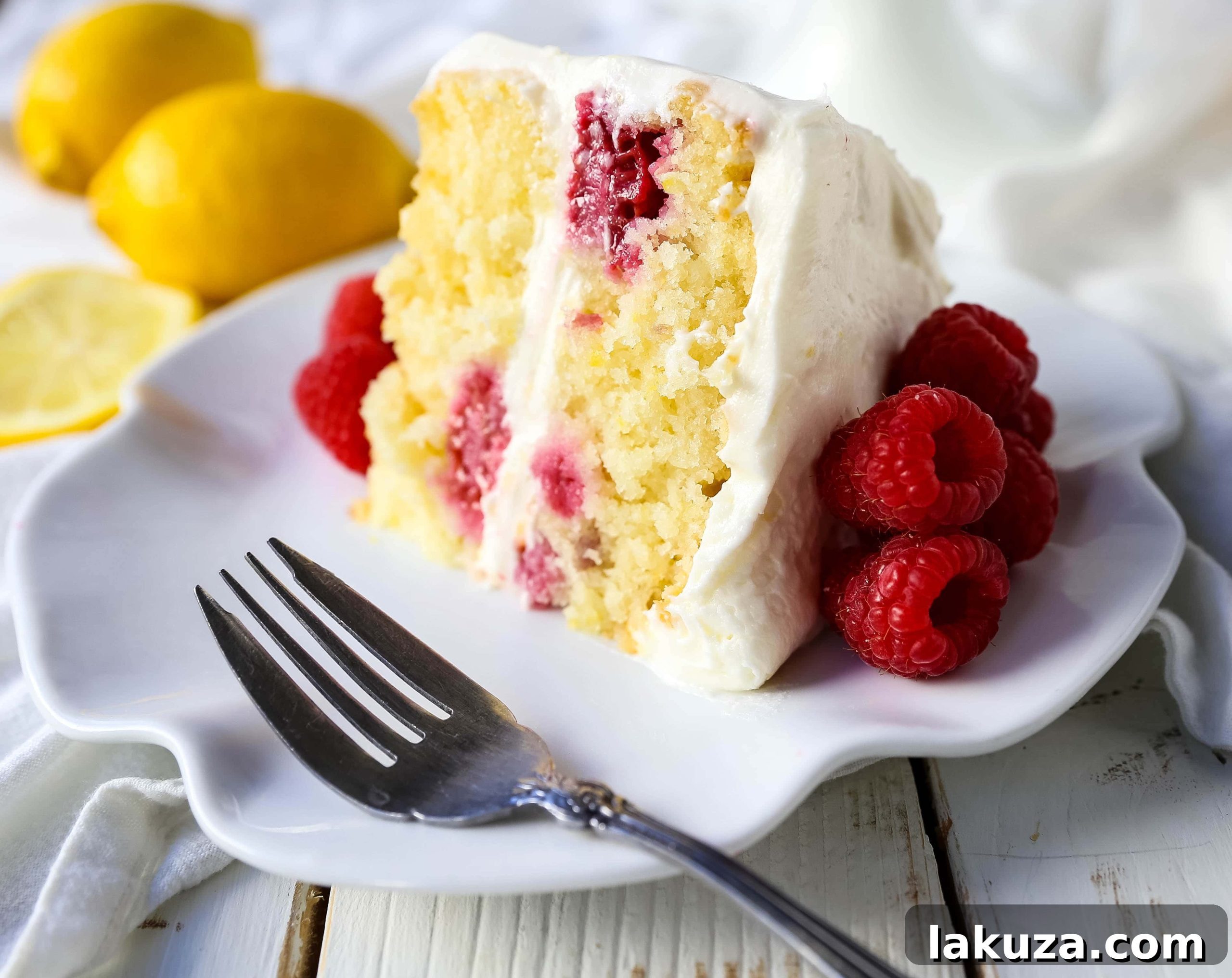 The Best Lemon Raspberry Cake. A light and fluffy lemon cake with fresh raspberries and a fresh lemon cream cheese frosting. A sweet and tangy lemon berry cake! #lemoncake #cake #lemonraspberrycake