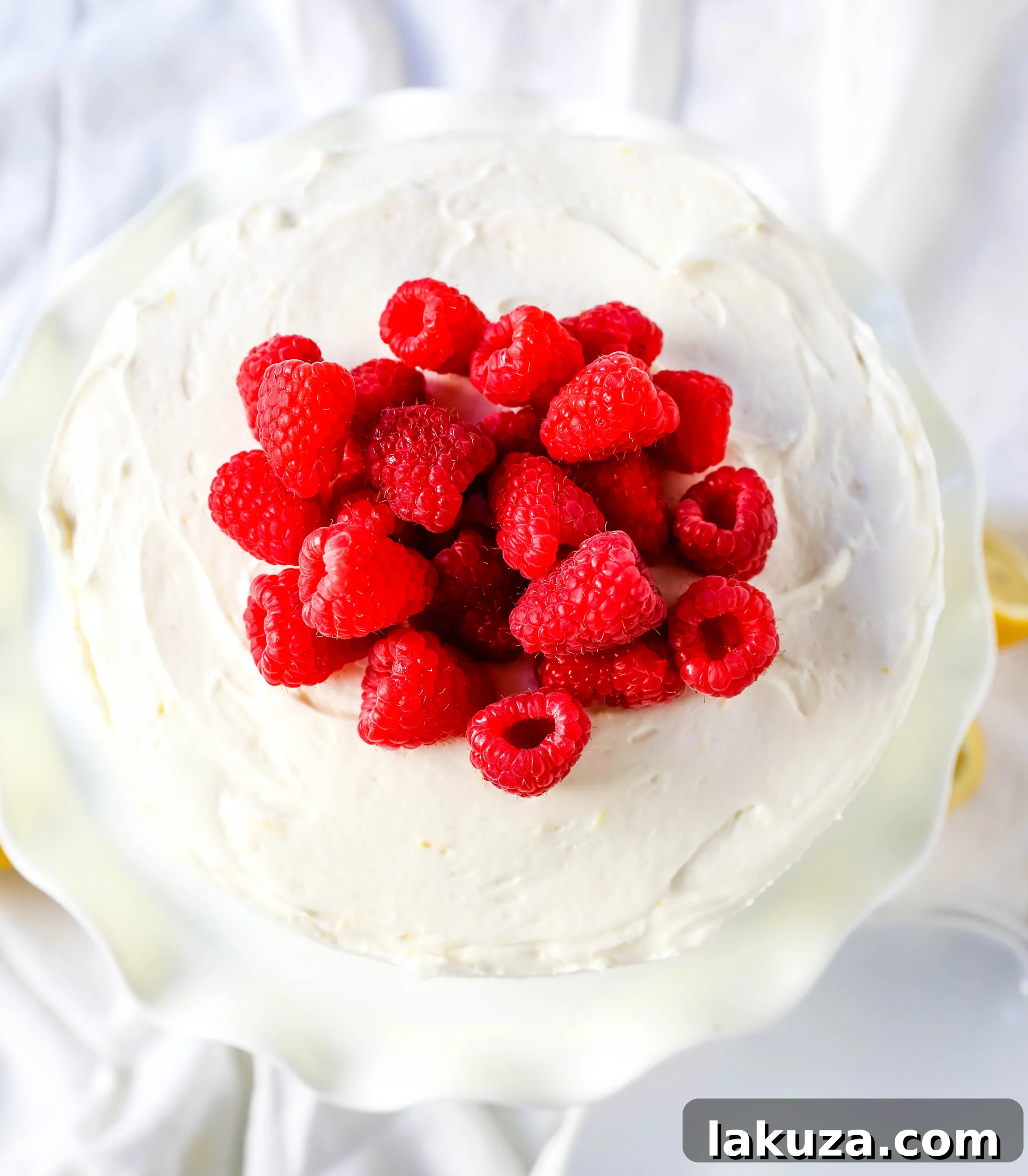 The Best Lemon Raspberry Cake. A light and fluffy lemon cake with fresh raspberries and a fresh lemon cream cheese frosting. A sweet and tangy lemon berry cake! #lemoncake #cake #lemonraspberrycake