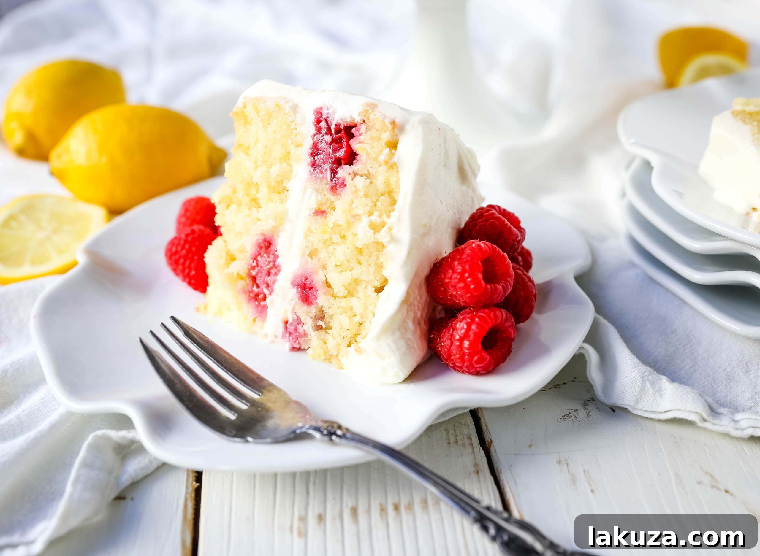 The Best Lemon Raspberry Cake. A light and fluffy lemon cake with fresh raspberries and a fresh lemon cream cheese frosting. A sweet and tangy lemon berry cake! #lemoncake #cake #lemonraspberrycake
