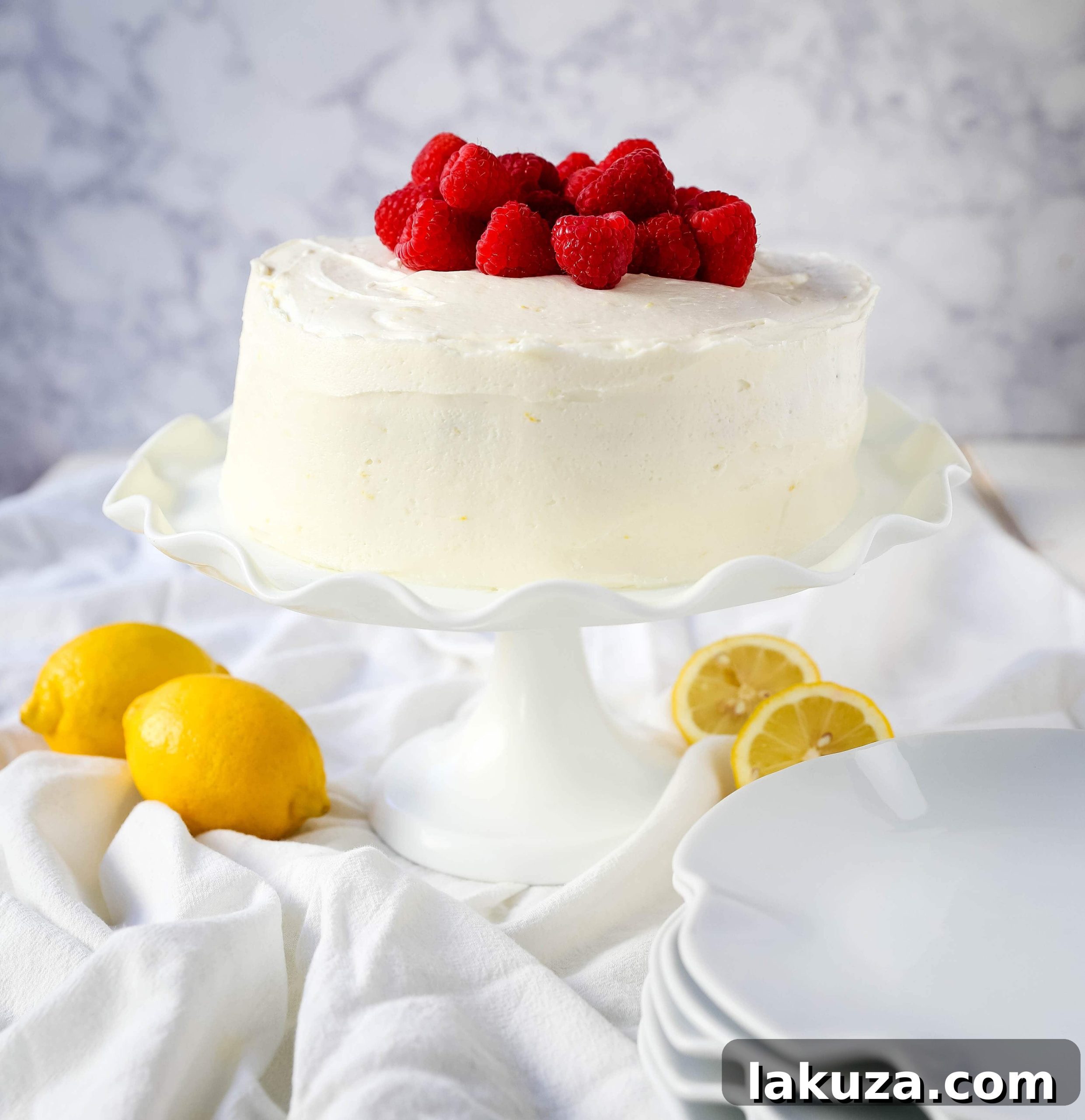 The Best Lemon Raspberry Cake. A light and fluffy lemon cake with fresh raspberries and a fresh lemon cream cheese frosting. A sweet and tangy lemon berry cake! #lemoncake #cake #lemonraspberrycake
