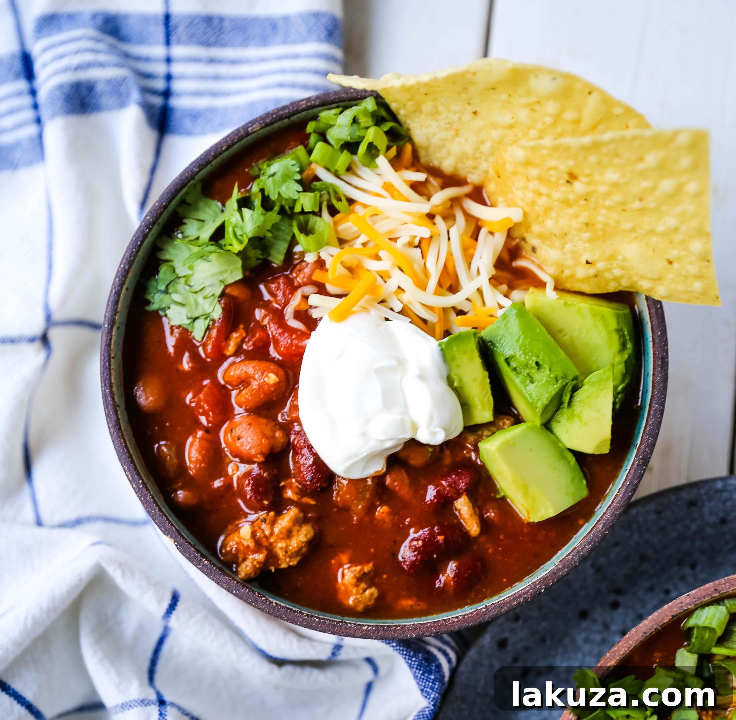 A wide shot of several bowls of turkey chili on a rustic table, inviting viewers to dig in