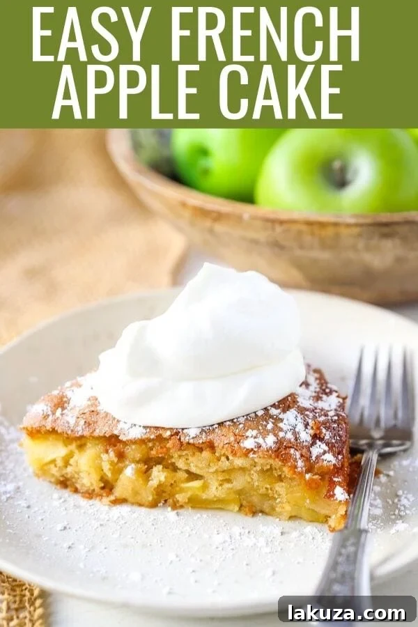 A single slice of French Apple Cake, beautifully plated with a generous serving of freshly whipped cream, inviting you to indulge in its rich flavors and tender texture.