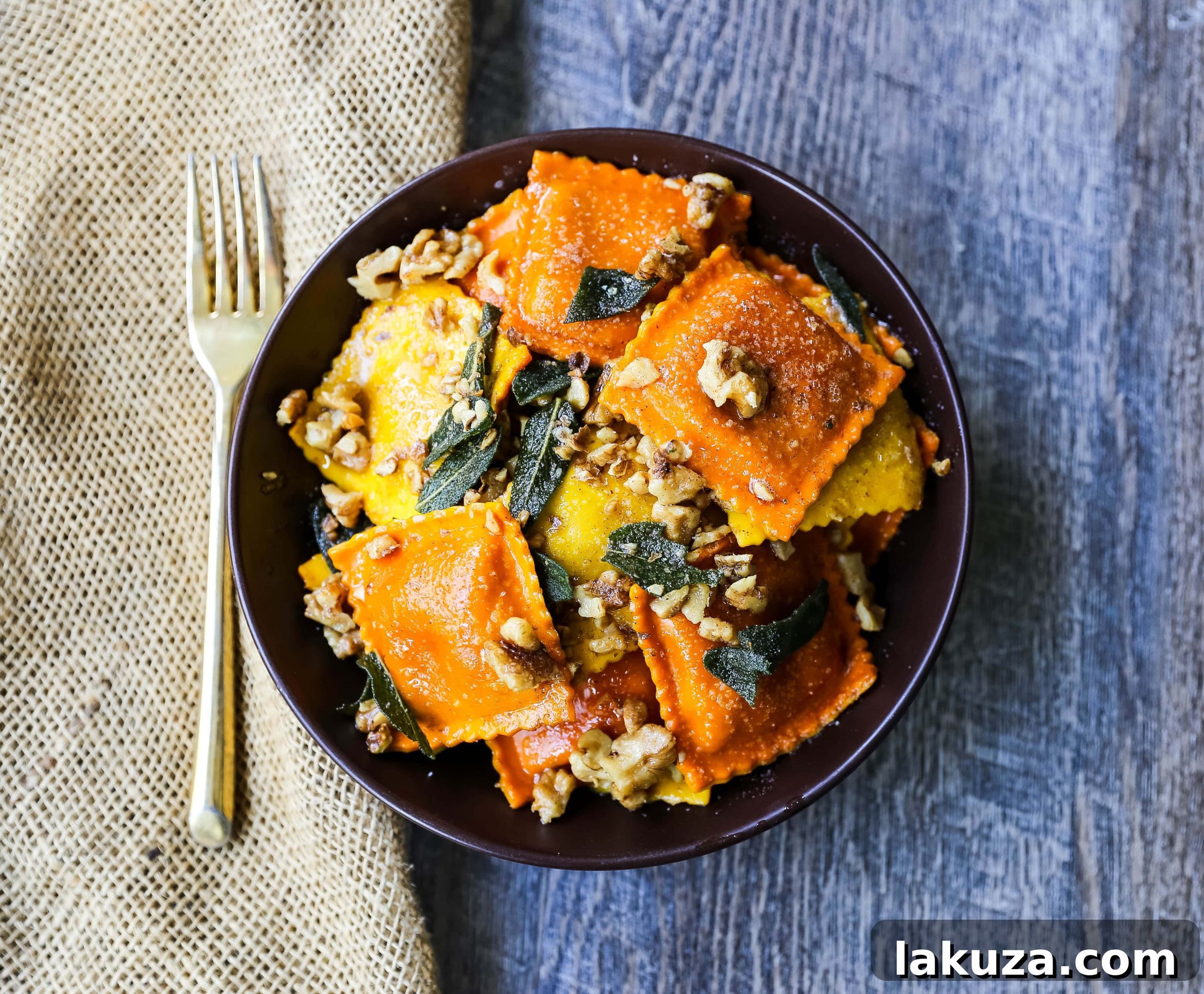 Nutty Brown Butter Sage Ravioli 4 A serving of pumpkin ravioli glistening with browned butter, topped with vibrant sage and crushed walnuts, ready to be enjoyed.
