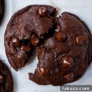 A double chocolate chip cookie split in half with melty chocolate. How to make the best double chocolate chip cookies.