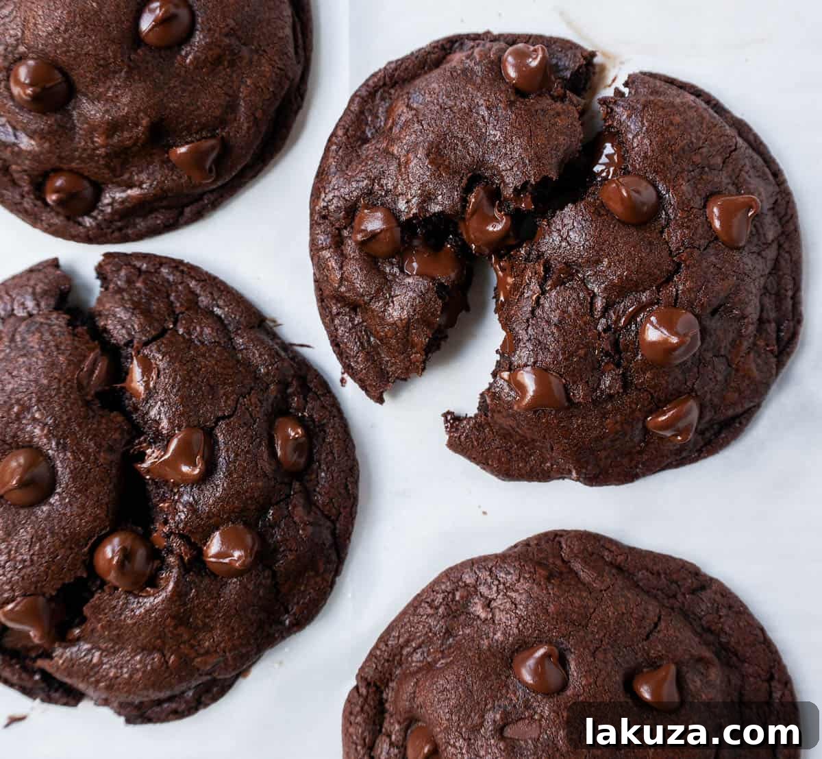A stack of three warm, soft, and fudgy double chocolate chip cookies, with visible melted chocolate chips. The image conveys the irresistible texture and rich chocolate flavor of this homemade cookie recipe.
