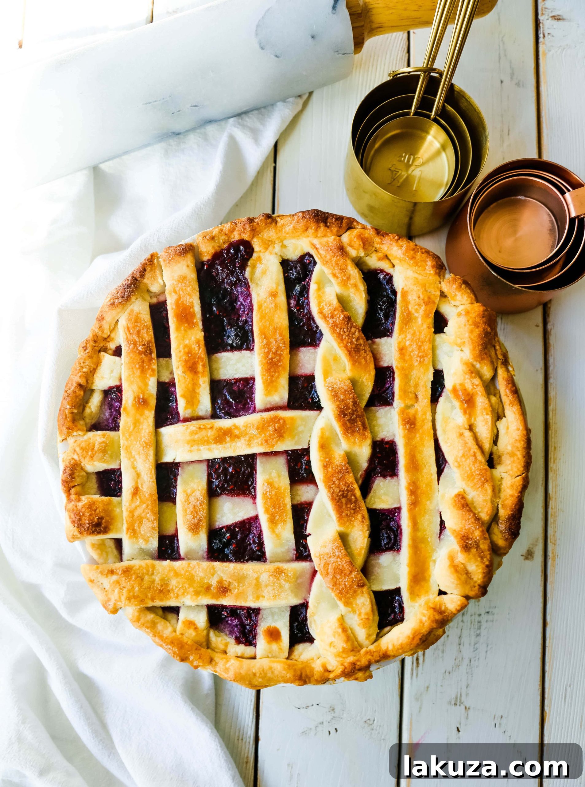 Berry Burst Pie 8 A top-down view of a Triple Berry Pie, showcasing its vibrant, rich filling and golden-brown crust, garnished with fresh berries and ready to be served.