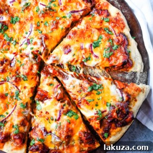 Homemade BBQ Chicken Pizza: Delicious pizza with BBQ Ranch Sauce, mozzarella, cheddar, chicken, red onion, and cilantro.
