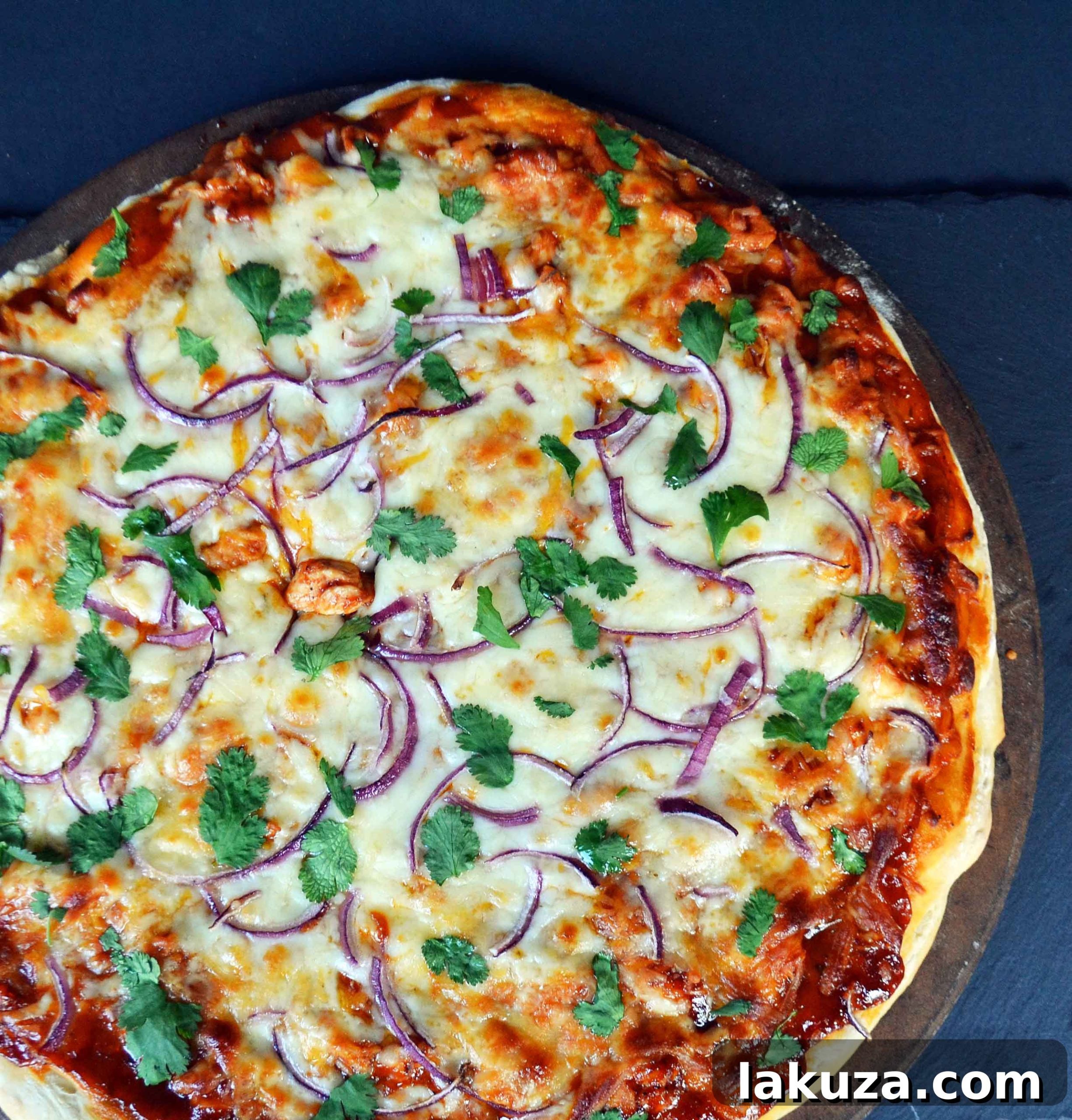 Gourmet BBQ Chicken Pizza at Home 4 A slice of Homemade BBQ Chicken Pizza, featuring chicken, red onion, and fresh cilantro on a golden crust.
