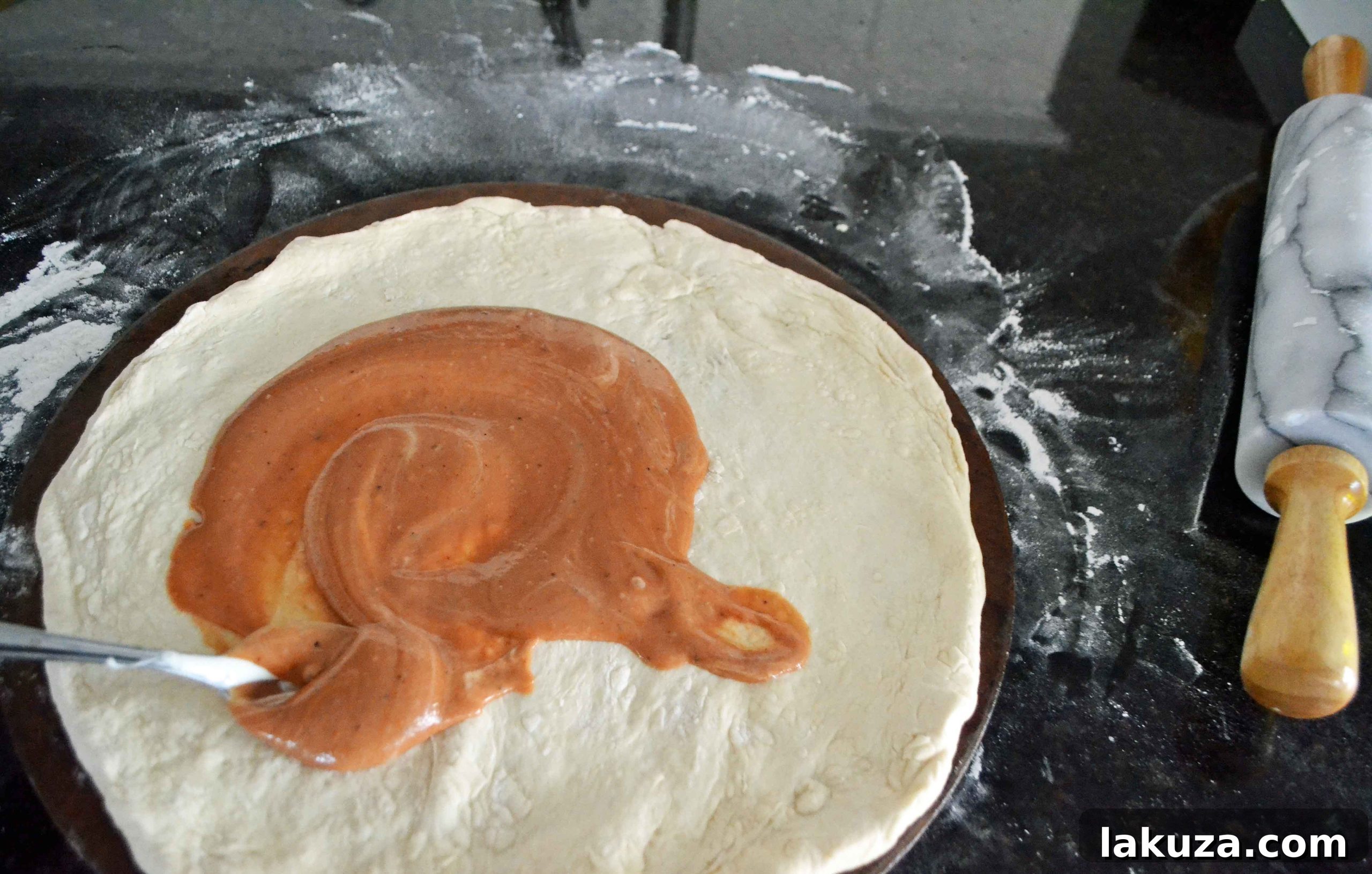 Gourmet BBQ Chicken Pizza at Home 7 The process of spreading the BBQ Ranch sauce onto the pizza dough, creating a vibrant base.
