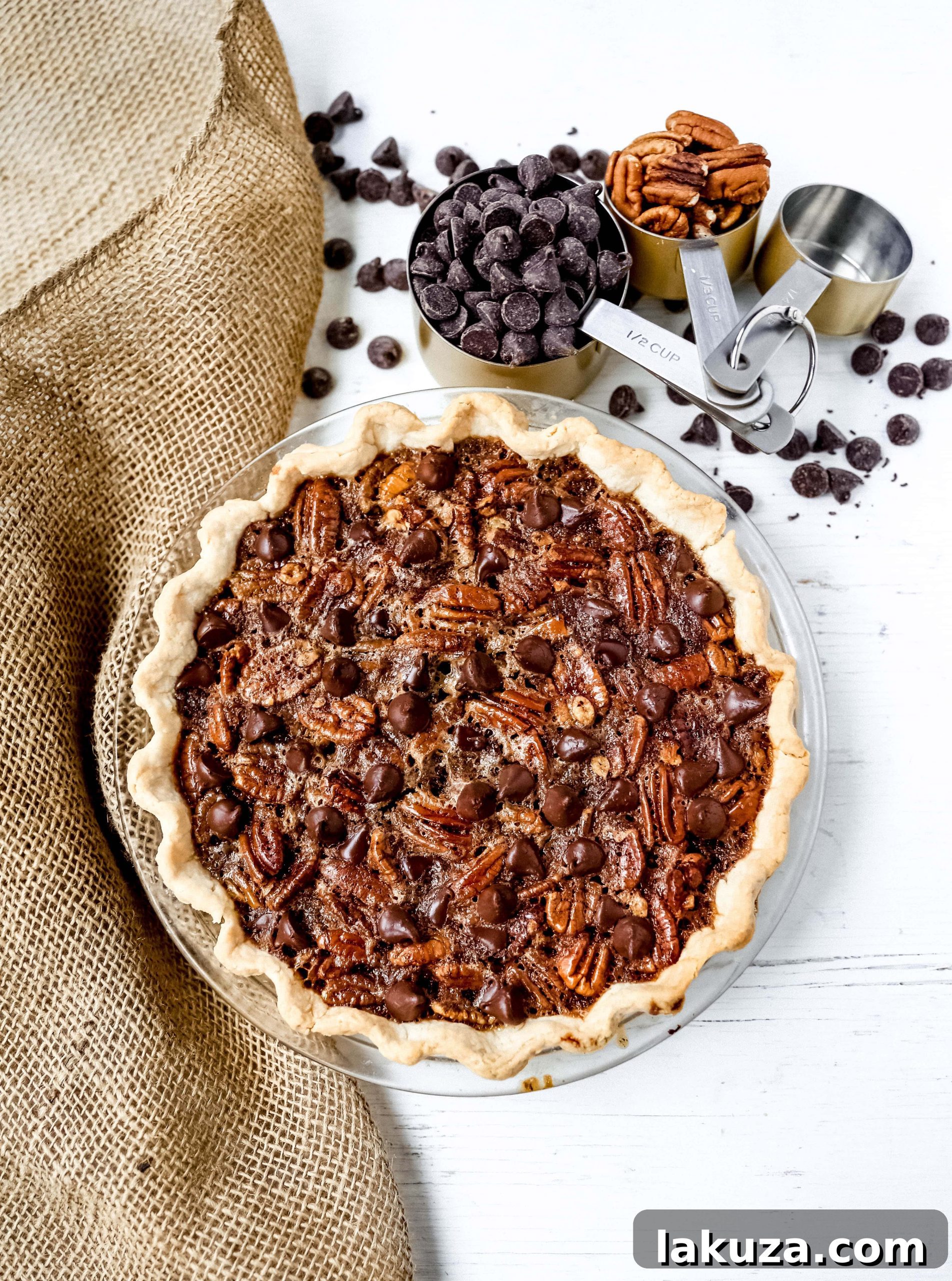 Close-up of a slice of Chocolate Pecan Pie showing chocolate chips and pecan halves