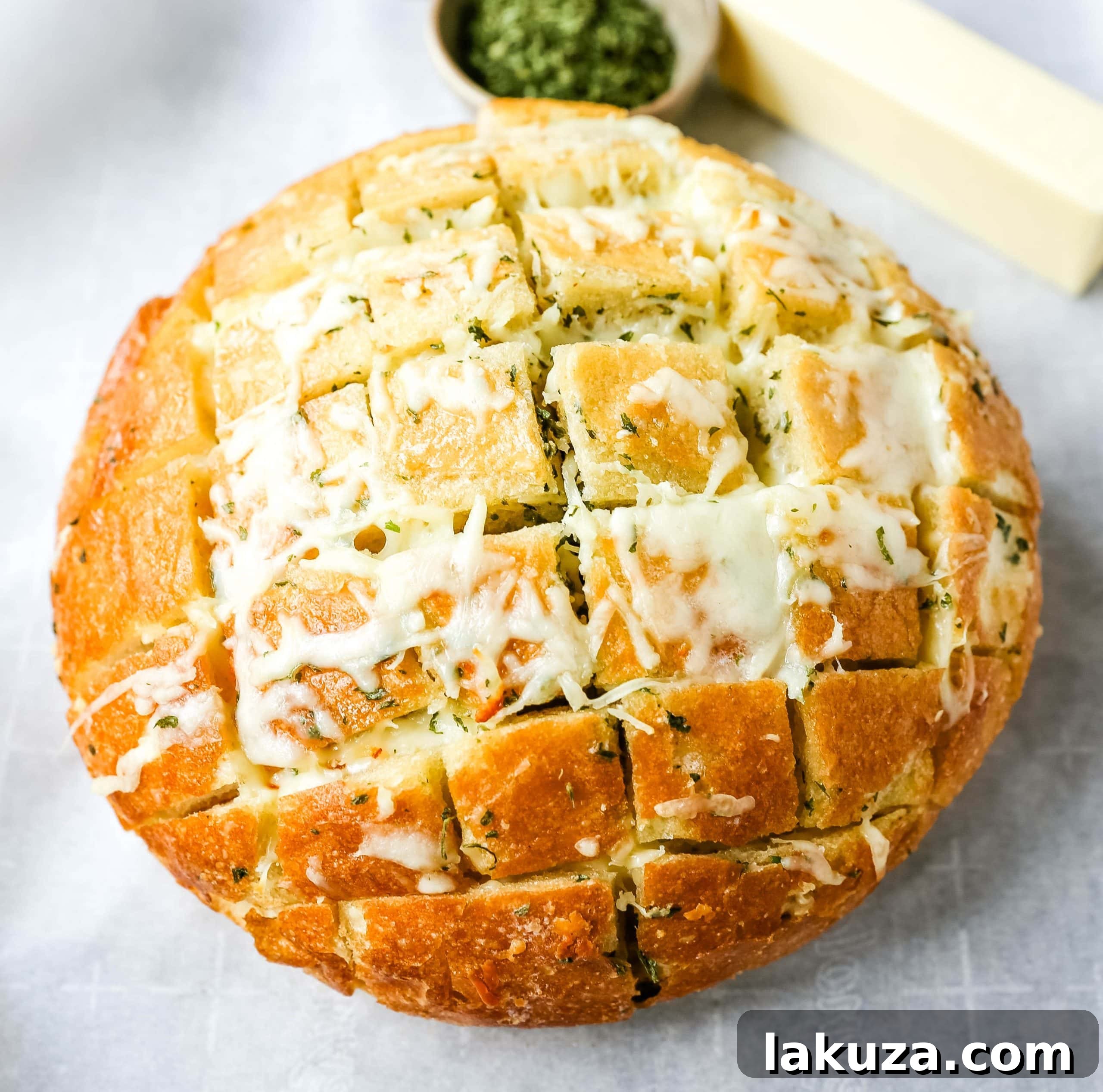 Golden brown cheesy pull-apart garlic bread on a wooden board, showcasing melted mozzarella and fragrant garlic butter