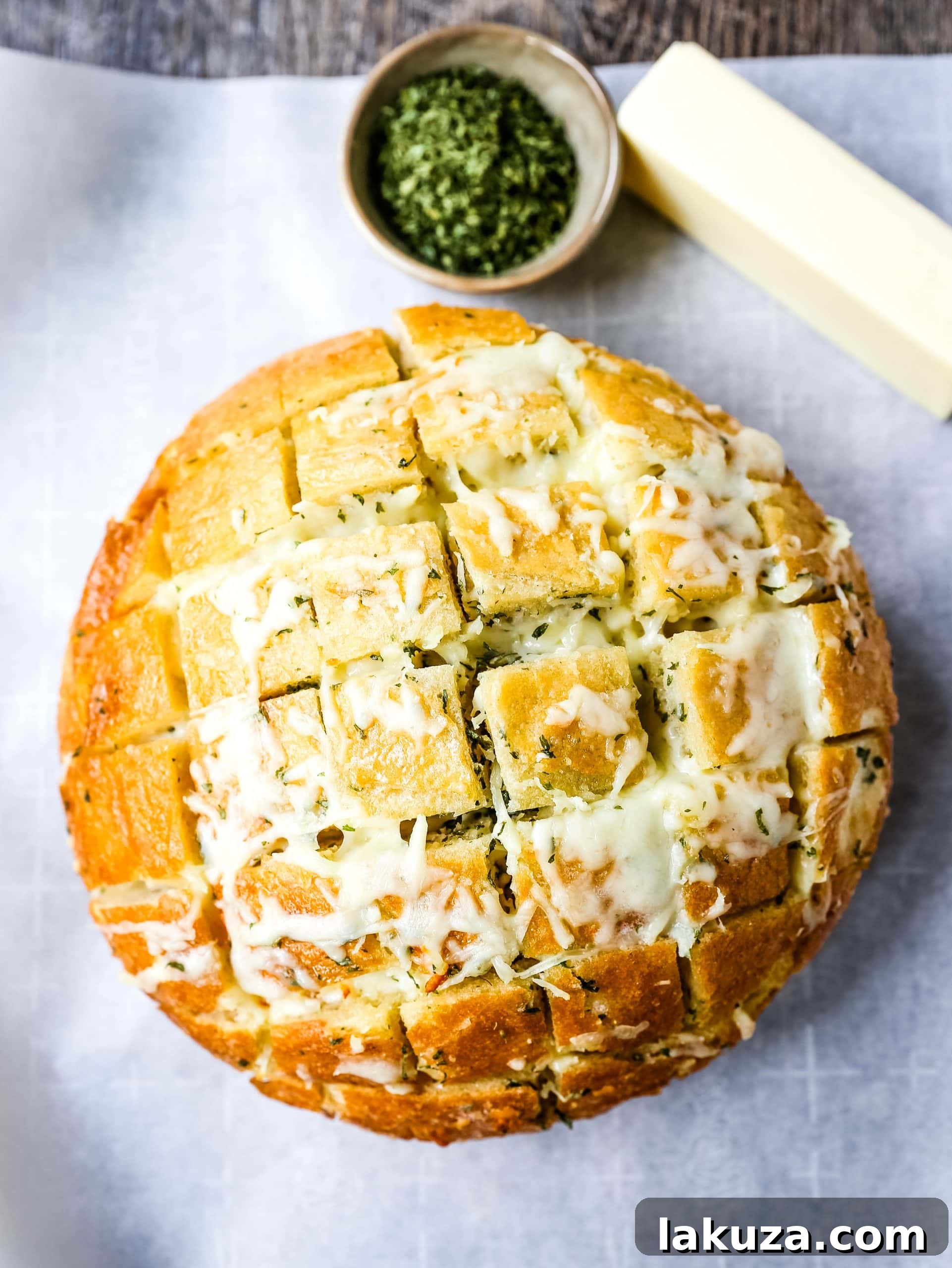 Close-up of pull-apart garlic bread revealing golden crust, melted cheese in every crevice, and a sprinkle of fresh parsley