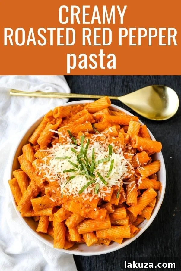A bowl of Creamy Roasted Red Pepper Pasta, ready to be served, topped with Parmesan.