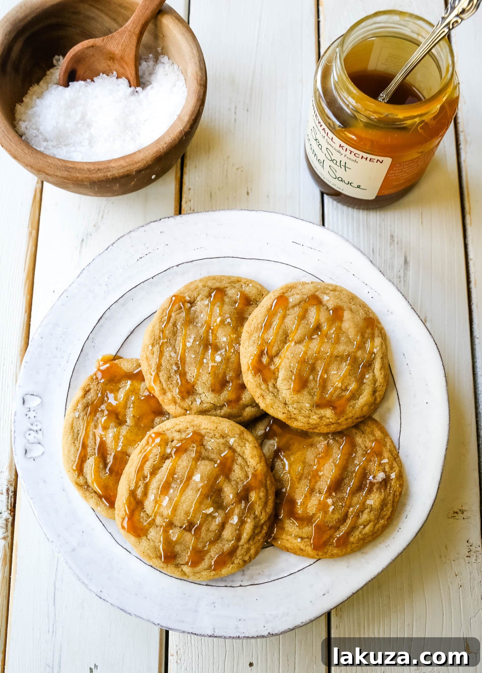 Salted Caramel Cookie Delights 3 Close-up of a stack of golden brown salted caramel cookies with a generous caramel drizzle and sea salt flakes.
