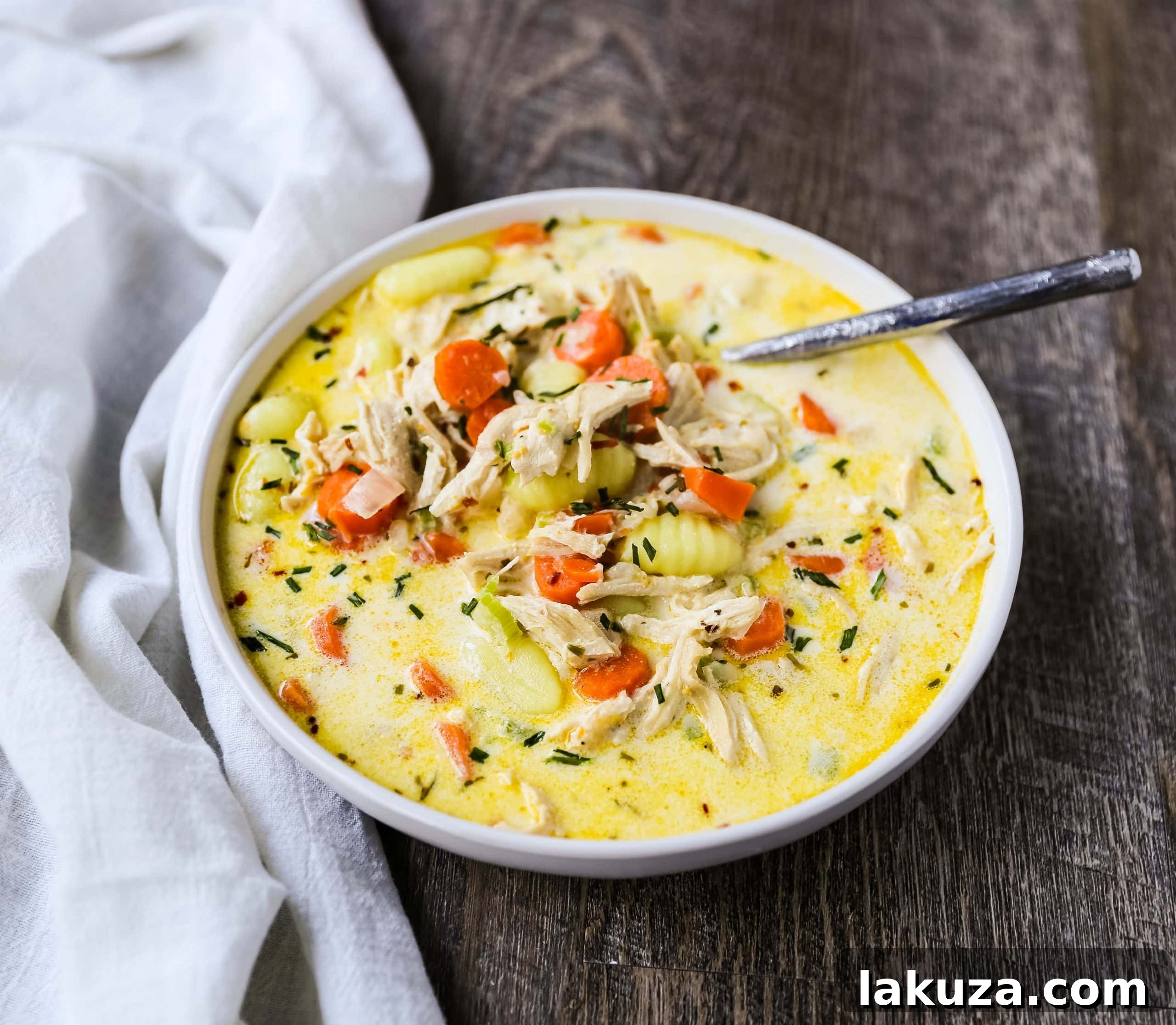 Close-up of creamy gnocchi chicken soup with soft gnocchi pasta and shredded chicken.