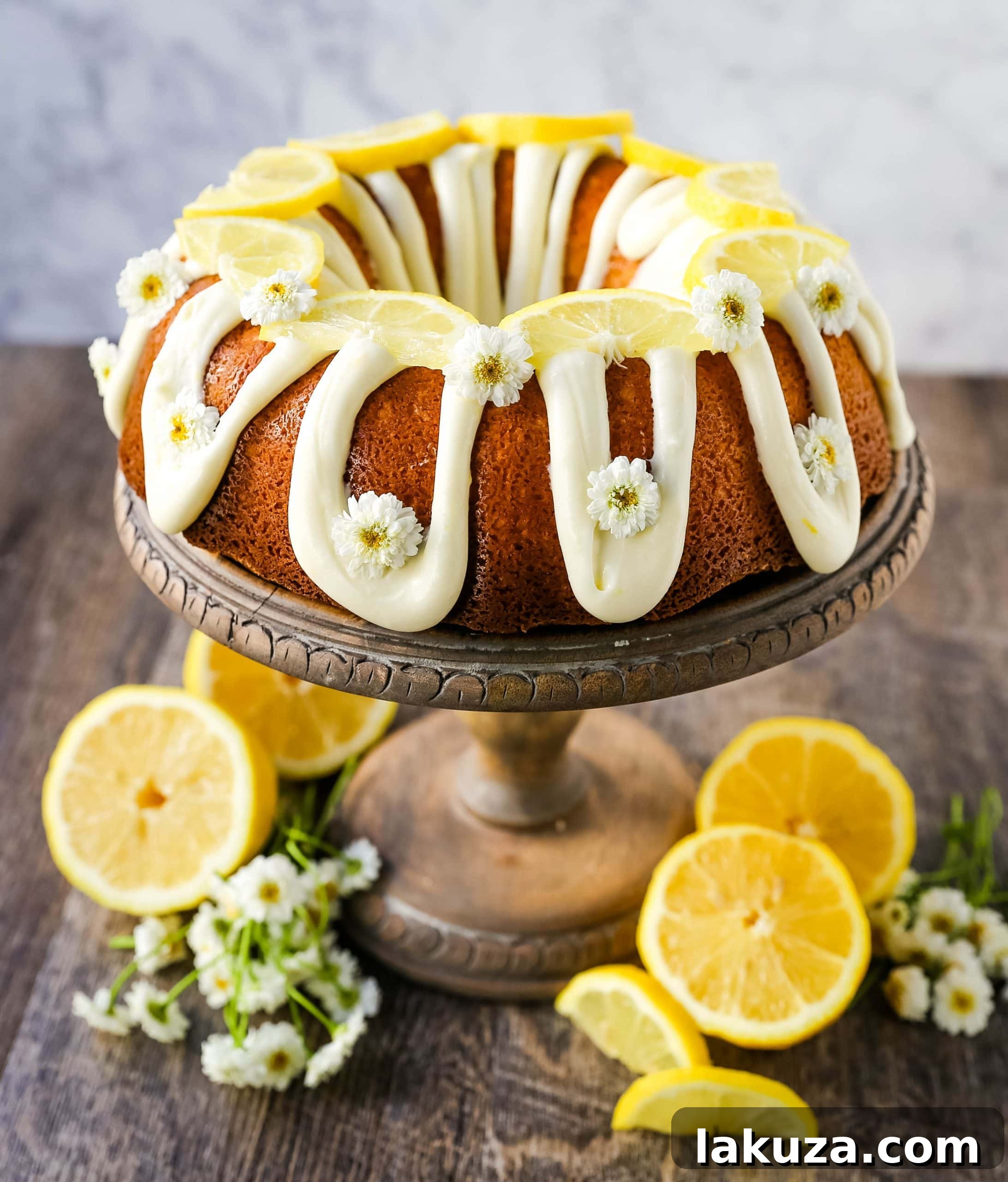 A beautifully glazed lemon bundt cake, dusted with powdered sugar and garnished with fresh lemon slices.