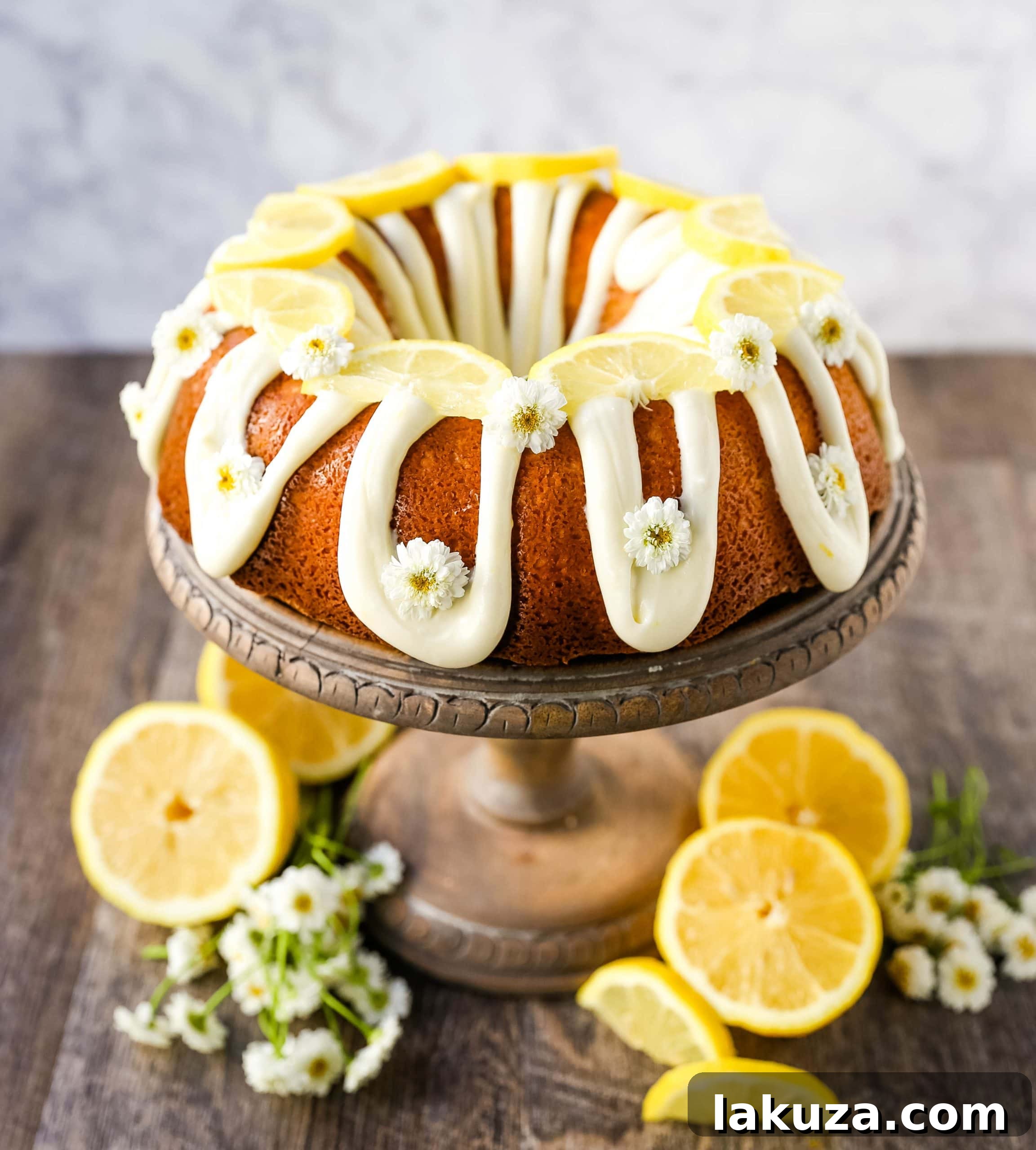 A whole lemon bundt cake with a luscious cream cheese glaze, ready to be served on a rustic wooden board.