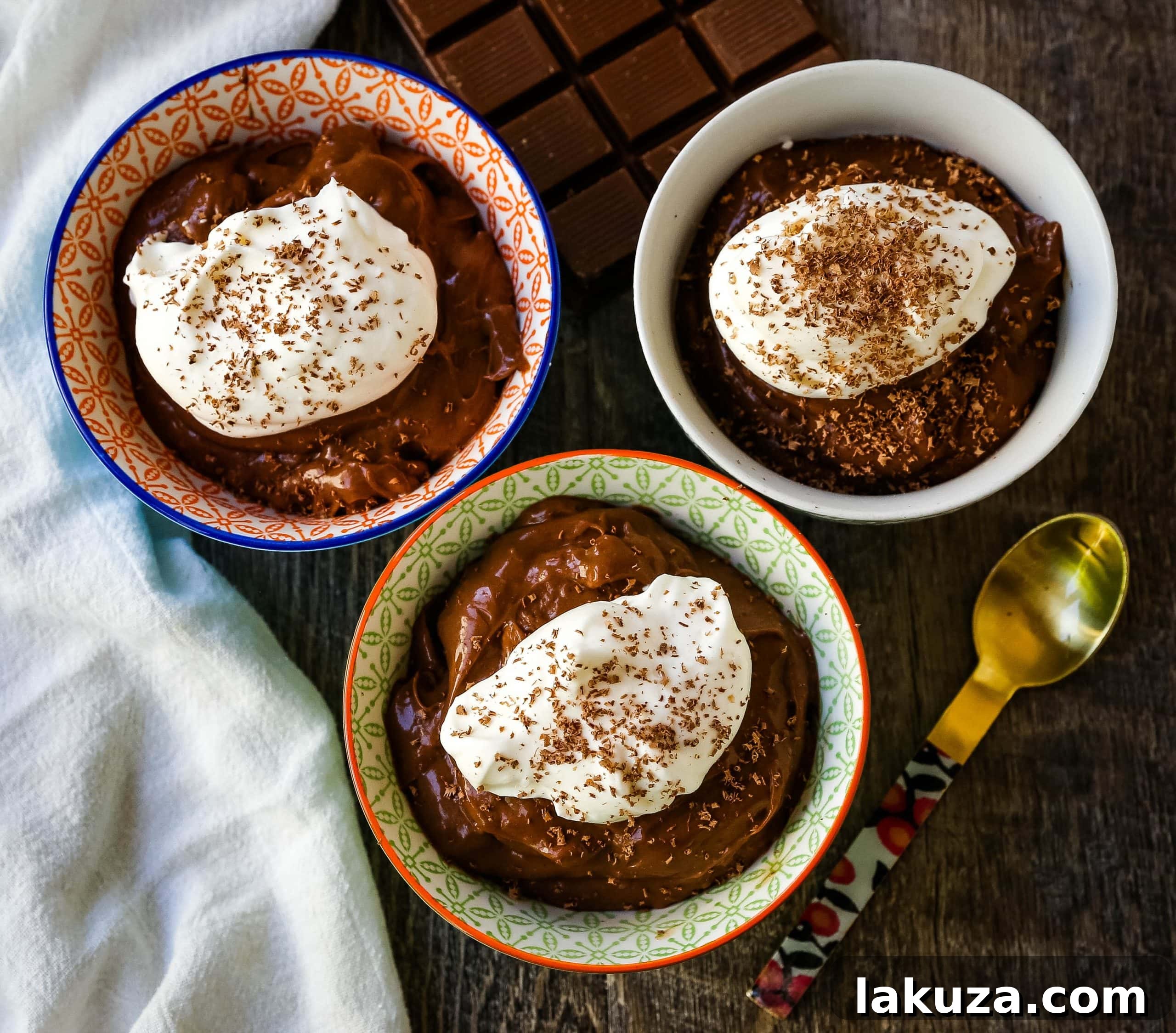 Silky smooth homemade chocolate pudding in a glass dish, garnished with chocolate shavings, highlighting its rich texture and inviting appearance.