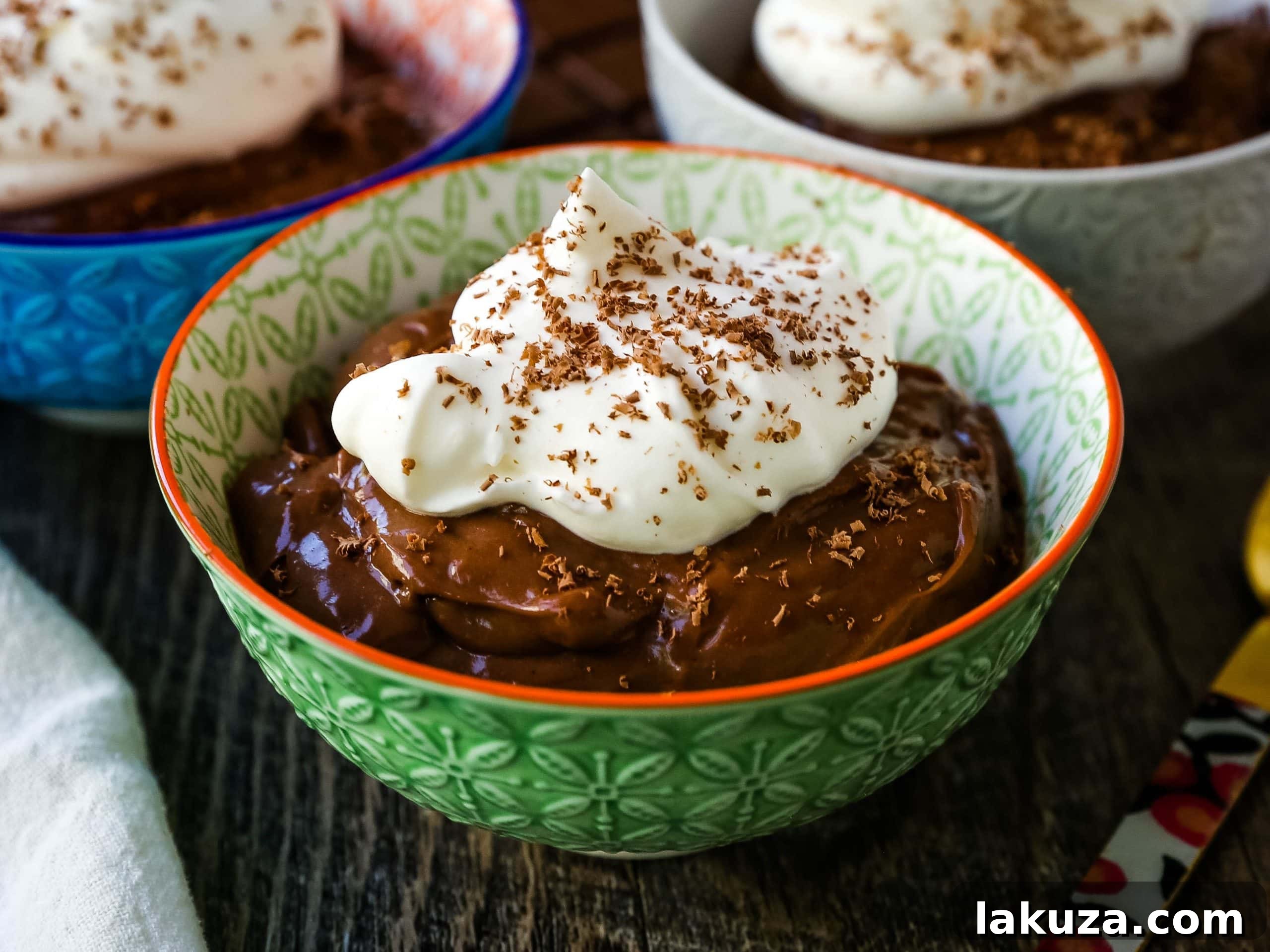 Close-up of a spoon scooping into rich, homemade chocolate pudding, showcasing its creamy, thick consistency and vibrant color.